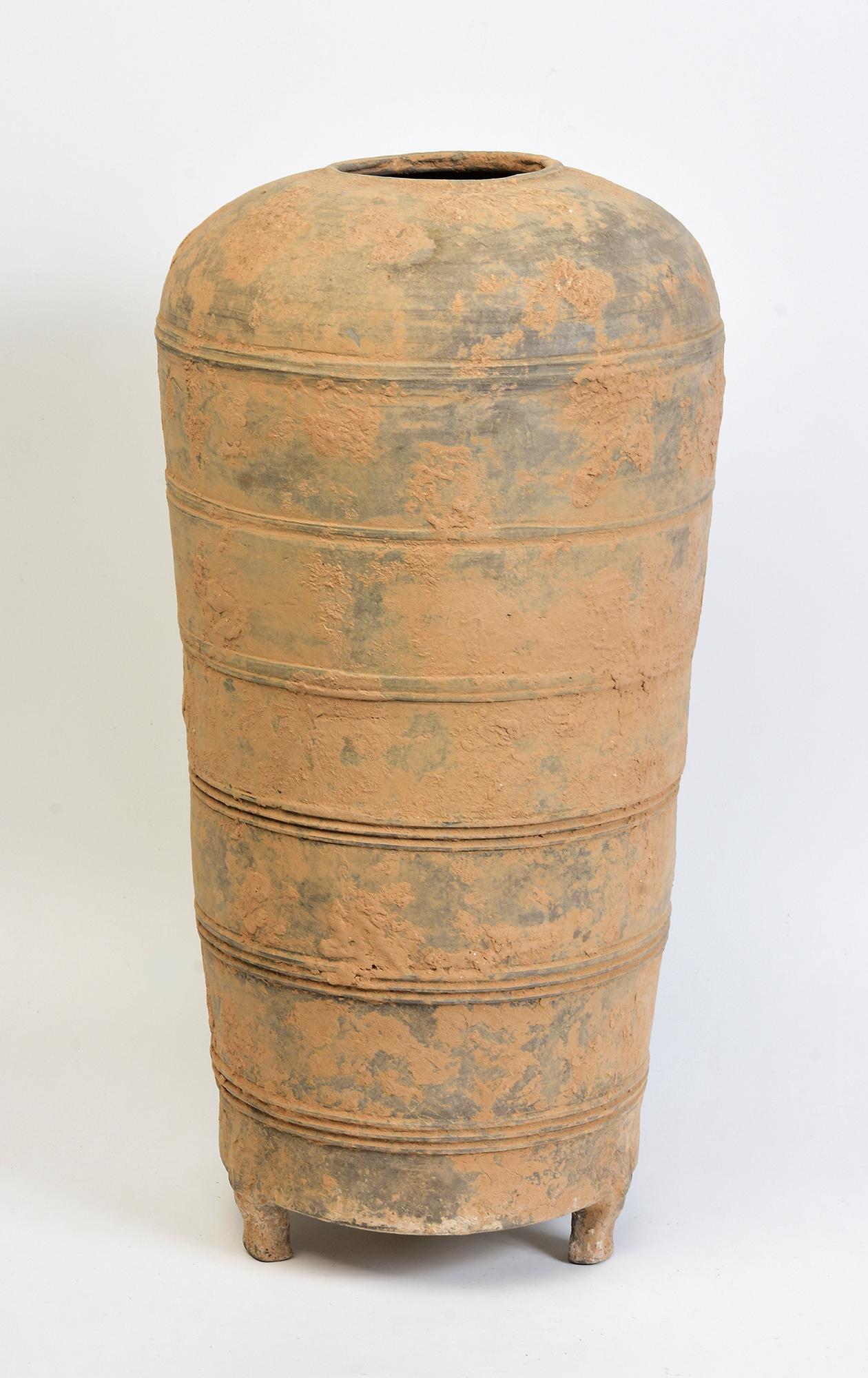 Antique Chinese pottery granary jar, with cylindrical shape, decorated with bands of incised lines, and supported by three legs.

Age: China, Han Dynasty, 206 B.C. - A.D. 220
Size: Height 46.3 C.M. / Width 23.3 C.M.
Condition: Well-preserved old