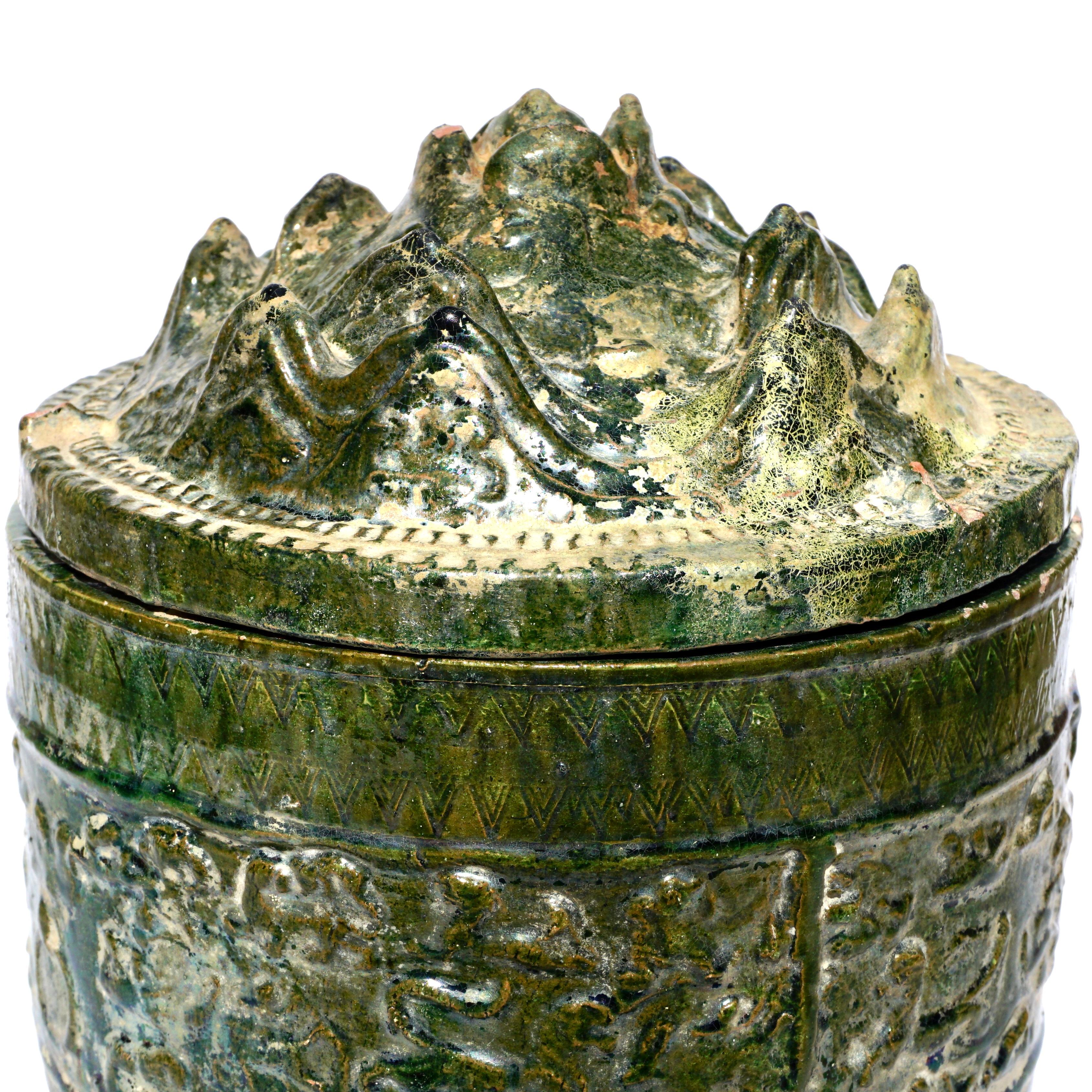 Han earthenware celedon glazed hill jar

The hill jar represents the five sacred mountains which is the path between the earth and Paradise. The mountains are filled with animals that live there. This jar might also represent either Mount Bo or