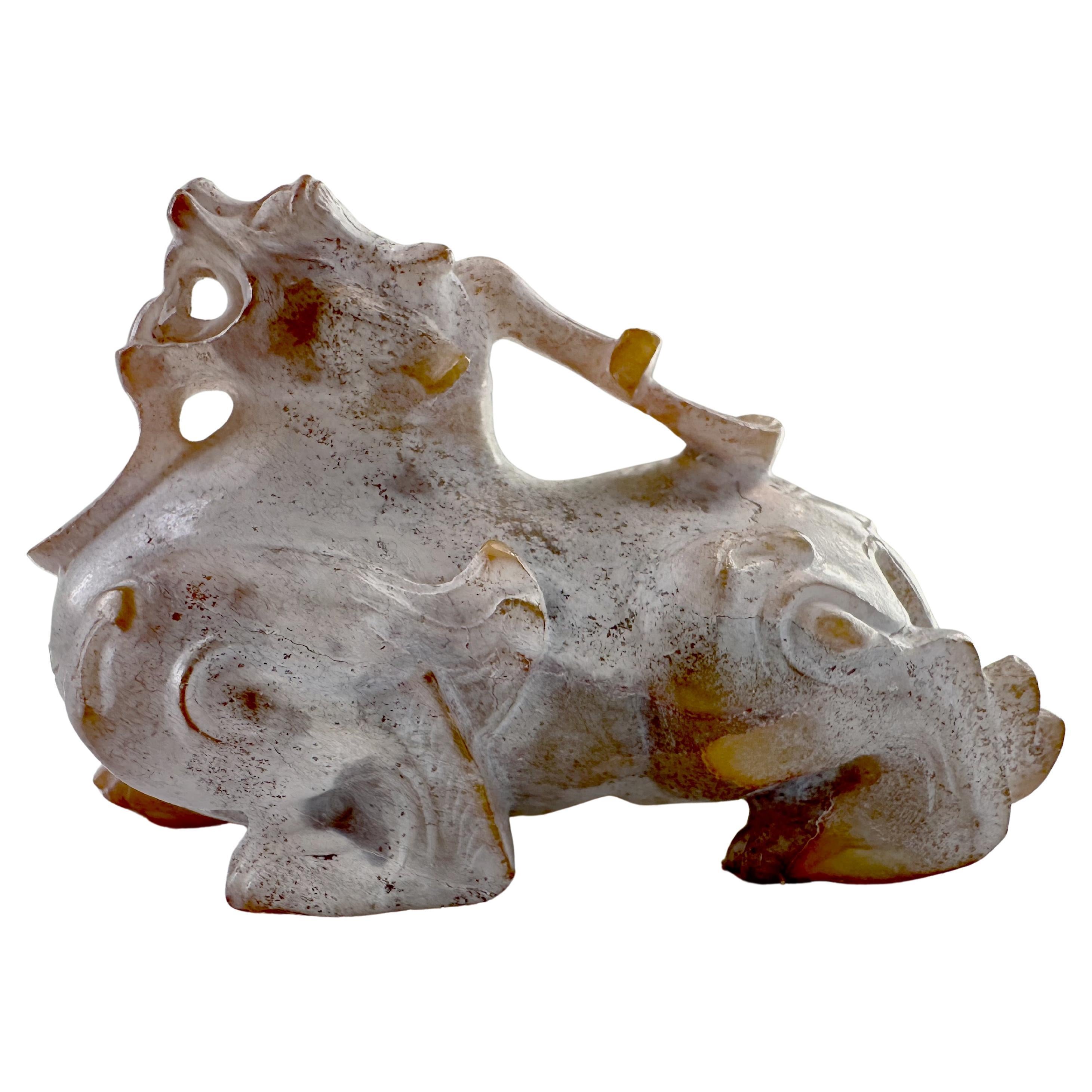 Han Dynasty Bixie, circa 206 BC to 220 AD, muscularly carved. The creature is depicted crouching on its powerful paws, its head thrown back, jaws open to reveal fangs, wings folded against its shoulders, and its horn touching its back.

The