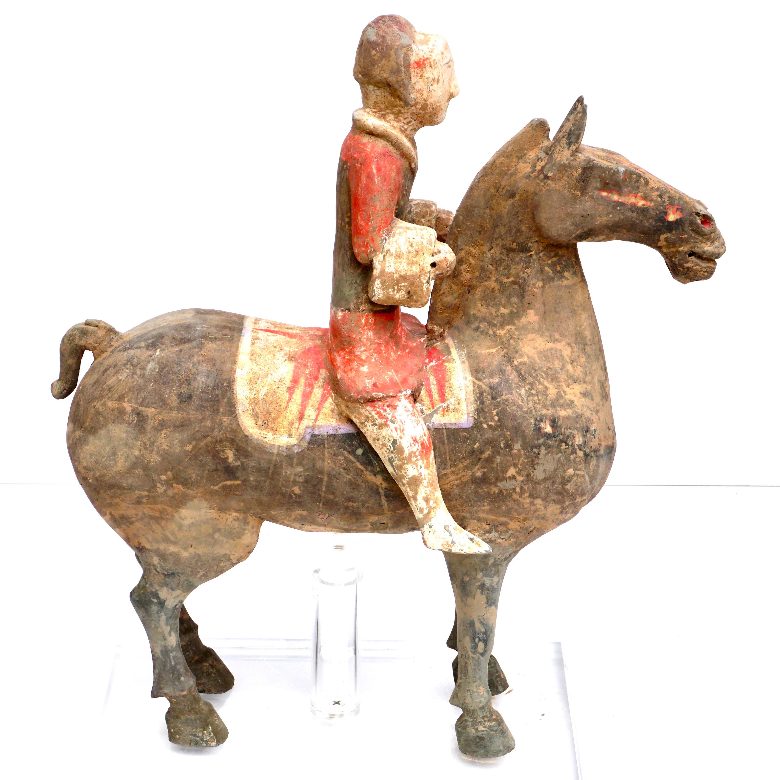 A fine Han dynasty polychrome painted terracotta horse and rider. The warrior is dressed in orange and black on a black horse.

Measures: Height 14 inches (35 cm)
Width 12.5 inches (32 cm).

Condition: Excellent with tastefully undetectable