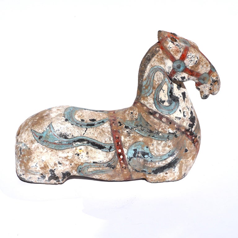 This pottery figurine is sculpted to show the strong, bold line and muscularity of the horse. Once part of an assembled set, this horse bears the characteristics associated with the famed Heavenly Horse of Fergana. Its long muscular neck, arched