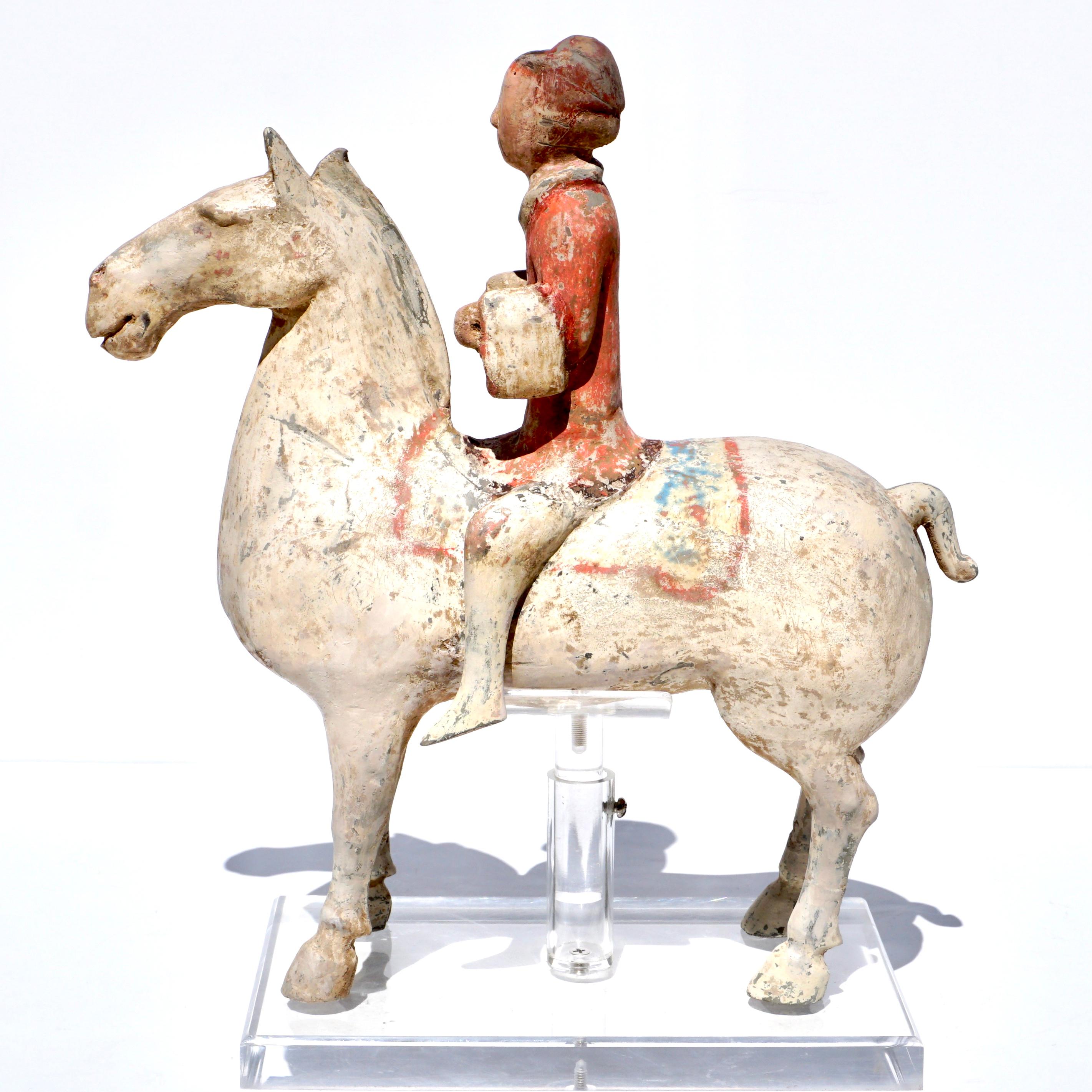 Han Dynasty painted pottery horse and rider

A Chinese Han Dynasty painted pottery horse & rider. Made from grey pottery and cold-painted in white, red and black pigments. The rider dressed as a warrior and in the pose of holding reins for the