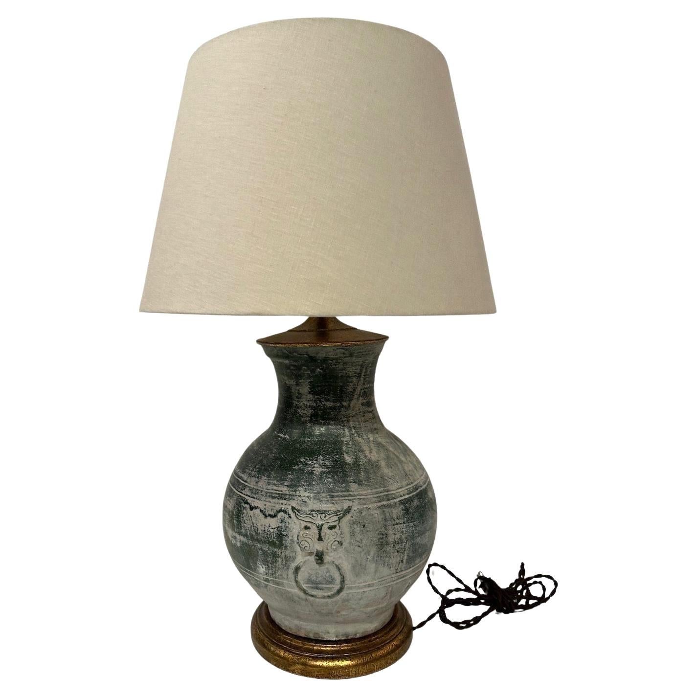 A circa 1920’s, Han Dynasty style vase, later made into a lamp mounted on a gilded wooden base.  Single bulb.  Woven shade.

Overall 27.75”H   Vase:  14”H x 12”Diam.  Shade:  17” Diameter
