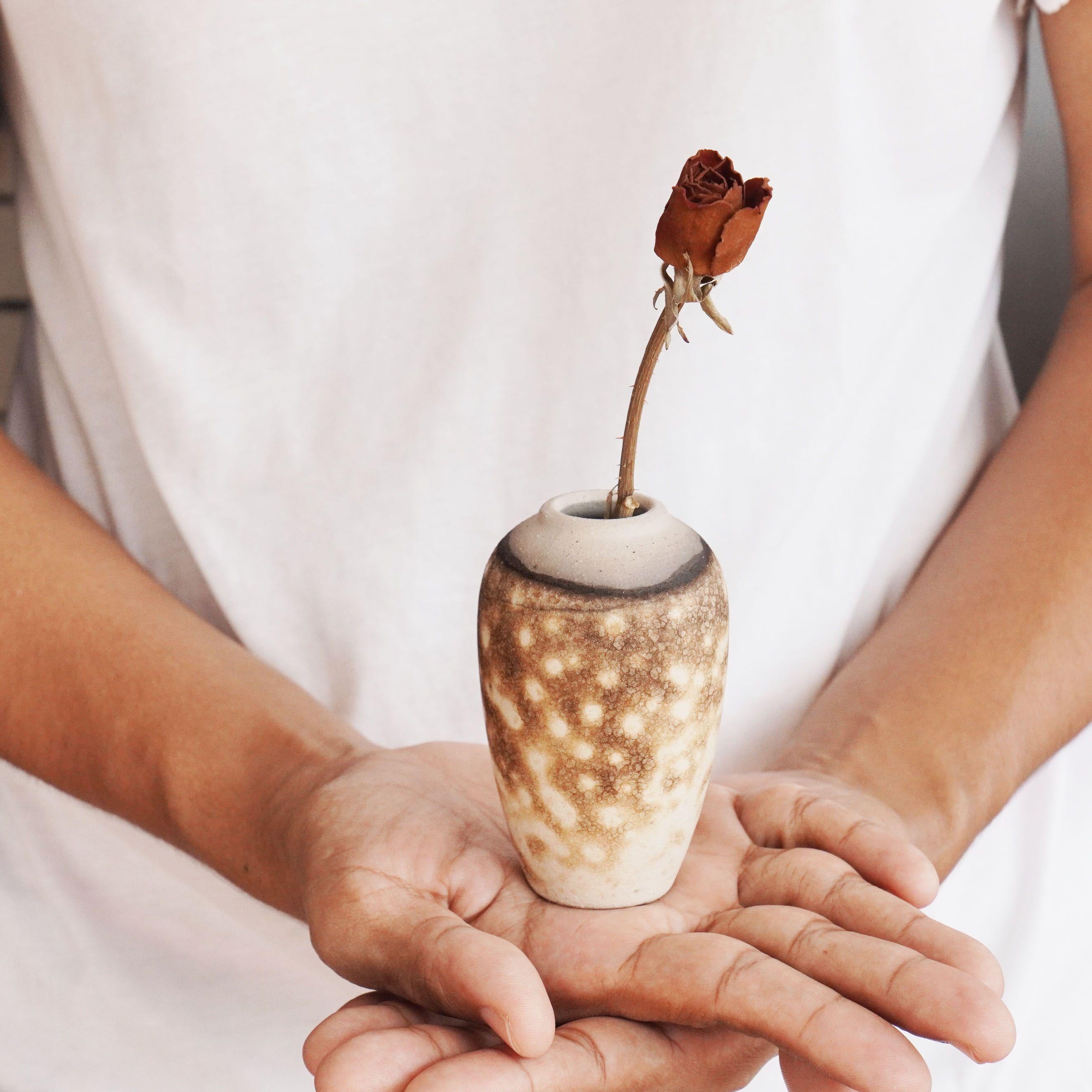 Hana L ~ 花 Flower.

Our Hana L mini raku vase represents a miniature urn with a bulbous top tapers slenderly to a smaller base. This vase makes for an adorable gift or a tabletop decorative piece that truly stands out. Each piece is individually