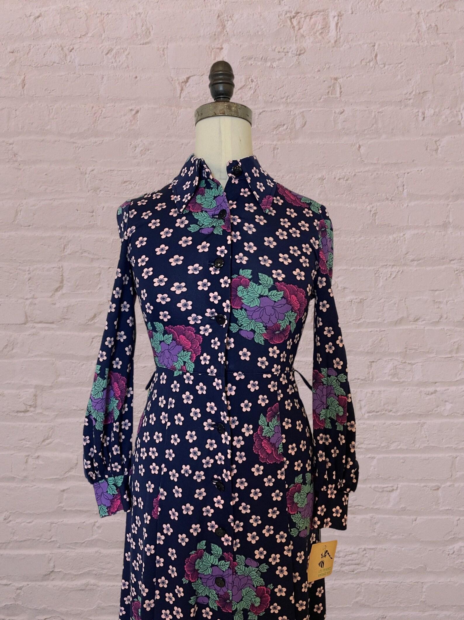 Vintage floral and leaf print long sleeved dress. pointed collar. a - line silhouette. fitted bodice & waist. dress falls to just above or at knee length. button front closure. inverted pleat skirt. missing belt. dry cleaned.

Circa 1970s
Hanae
