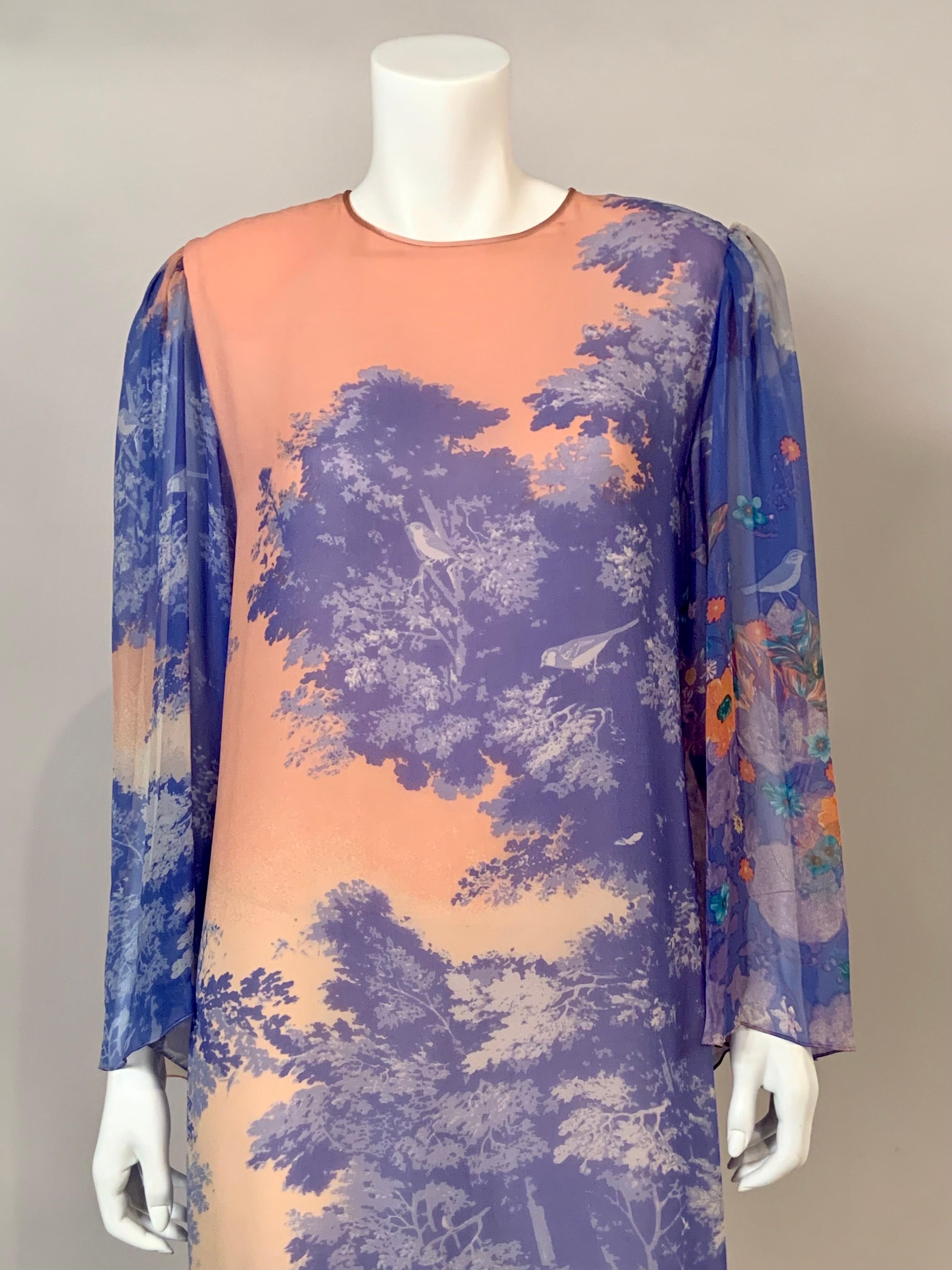 Hanae Mori designed this caftan or evening dress using printed silk chiffon in the 1980's.  The dress has a design of trees and birds in shades of blue cascading towards the hem.  It is lined in pink chiffon with full sheer sleeves.  There are