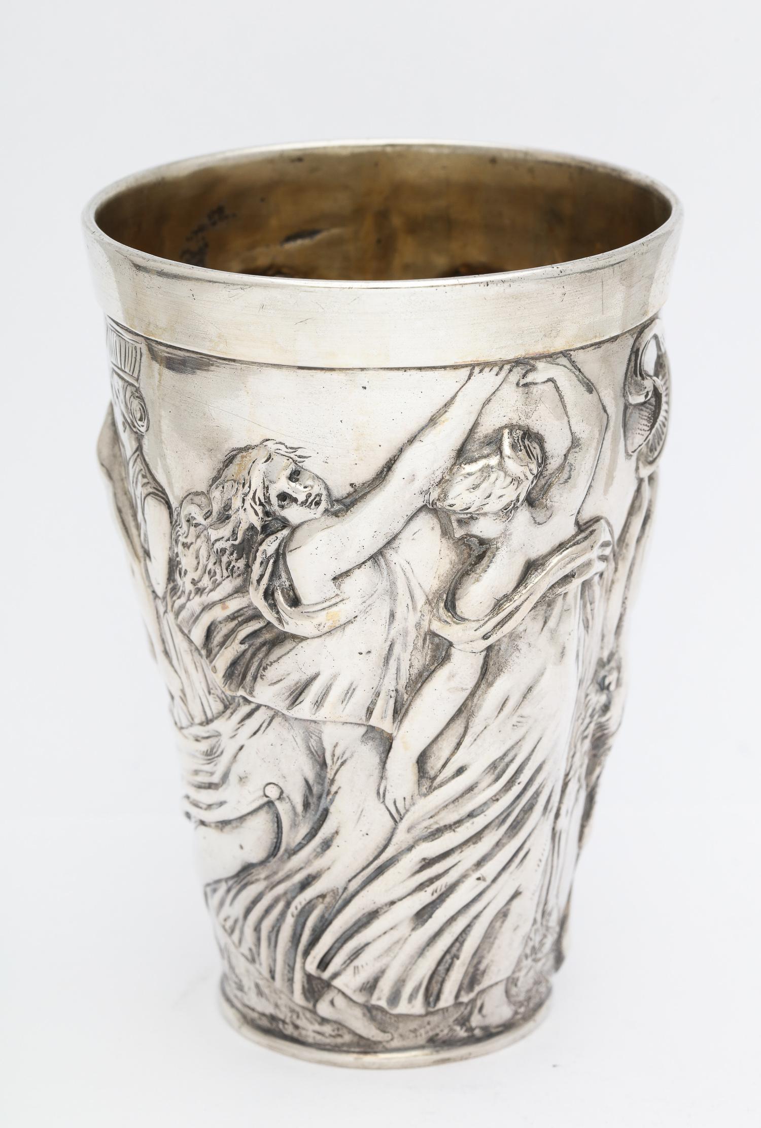 Hanau, Continental Silver (.800) beaker, Germany, circa 1900, Stork and Shinsheimer - makers. Decorated with a Bacchanalian scene. Measures 4 1/2 inches high x over 3 inches in diameter. Weighs 6.070 troy ounces. Lightly gilded interior. Dark spots
