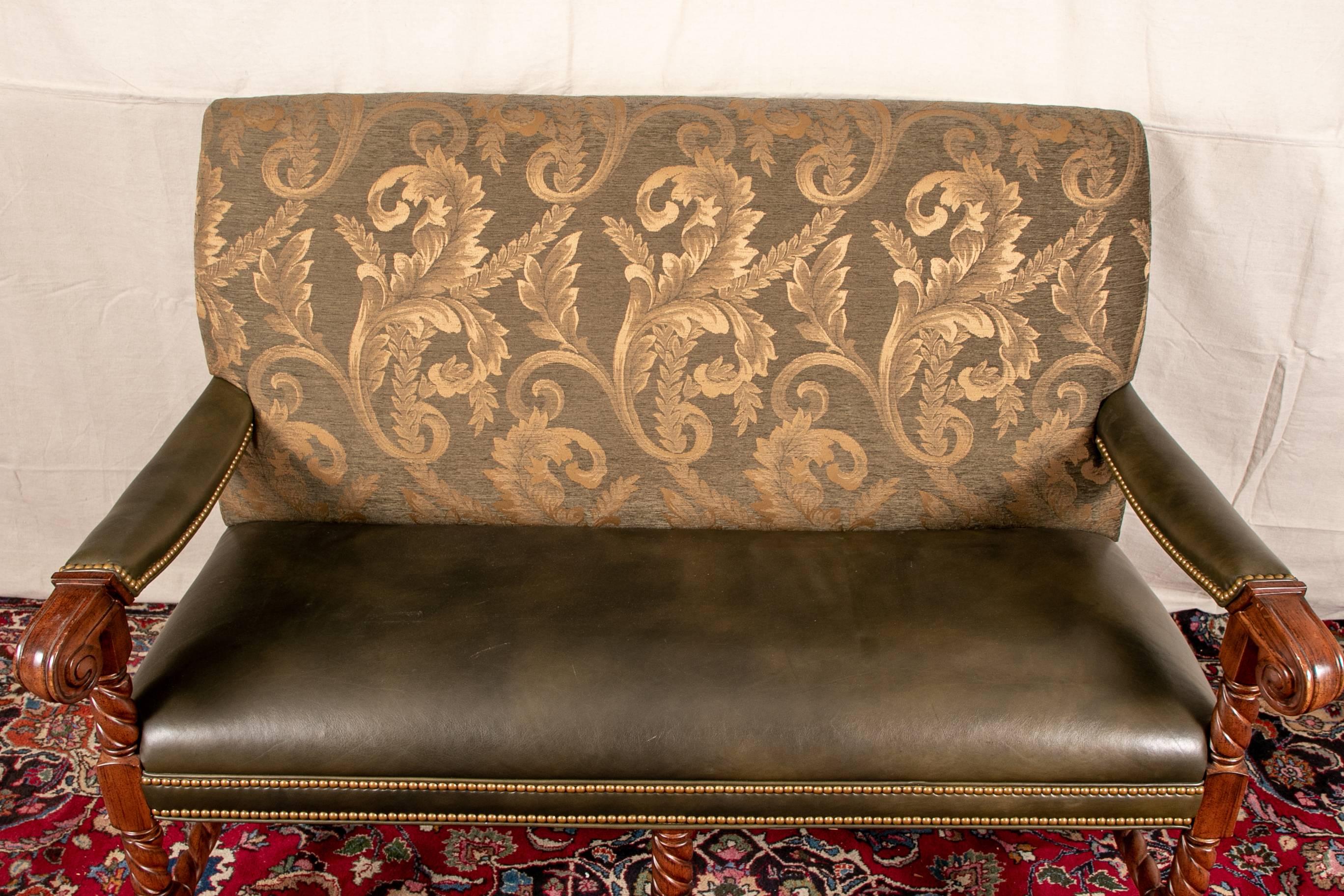 Leather and fabric settee made by Hancock and Moore with olive green leather seat and manchettes, back with olive green and gold fabric, carved armrests continuing down to legs, barley twist stretcher all around

Condition: Expected wear and signs