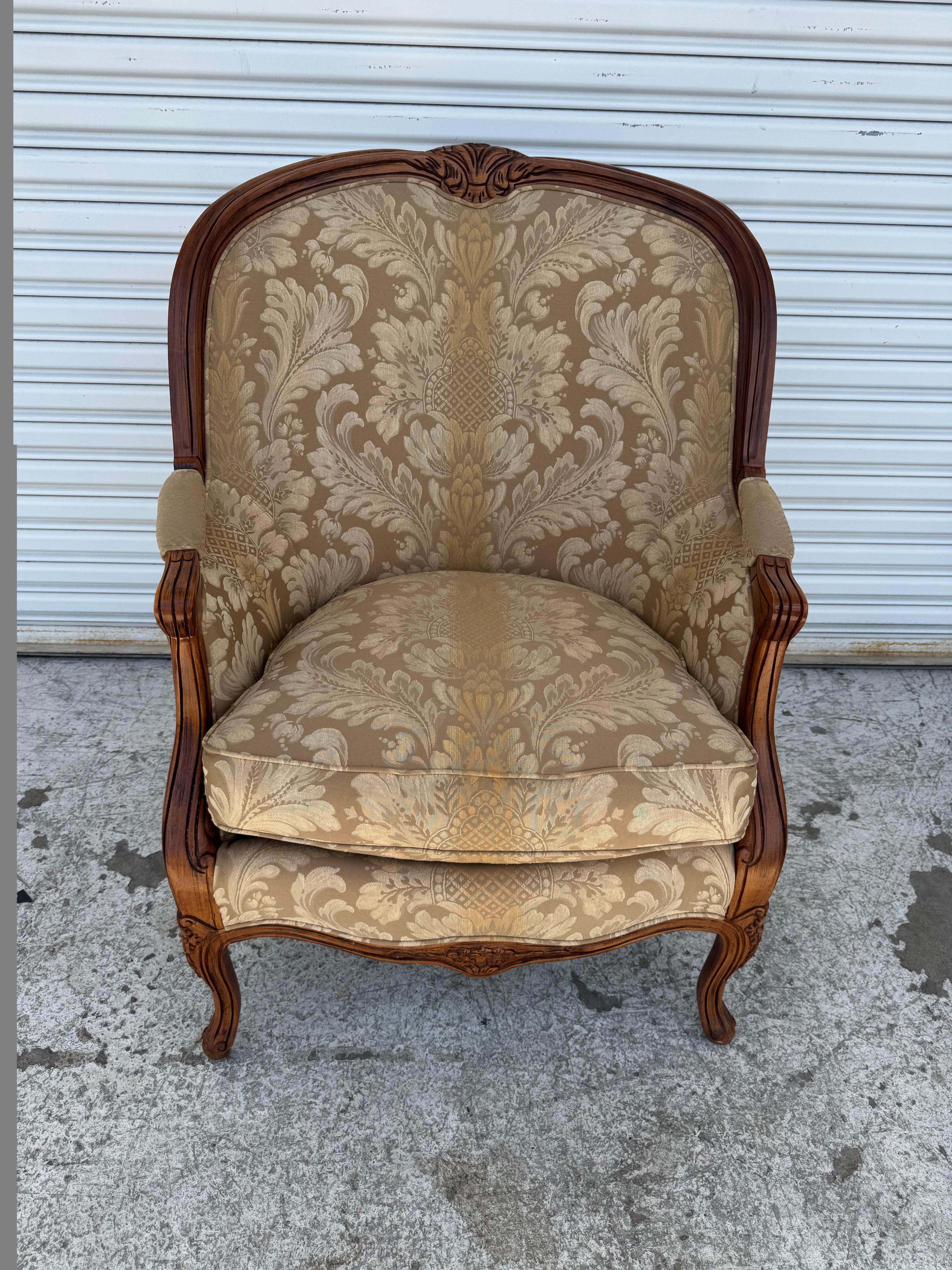 Hancock & Moore armchair exemplifies refined elegance and traditional craftsmanship, combining luxurious comfort with classic design. The solid wood frame showcases intricate carvings along the crest, arms, and cabriole legs, accentuating its