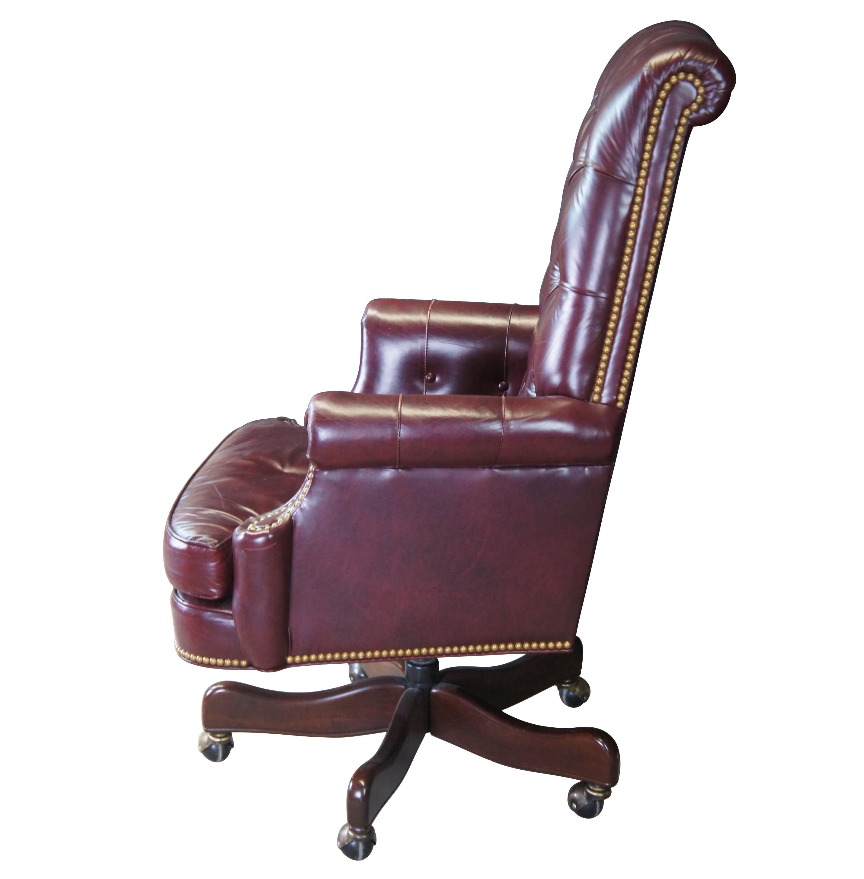 An exceptional leather executive office desk chair by Hancock & Moore.  Features a red leather tufted frame with scrolled arms and back.  Includes brass nail head trim and removable cushion.  The chair supported by a 5 leg mahogany finished base