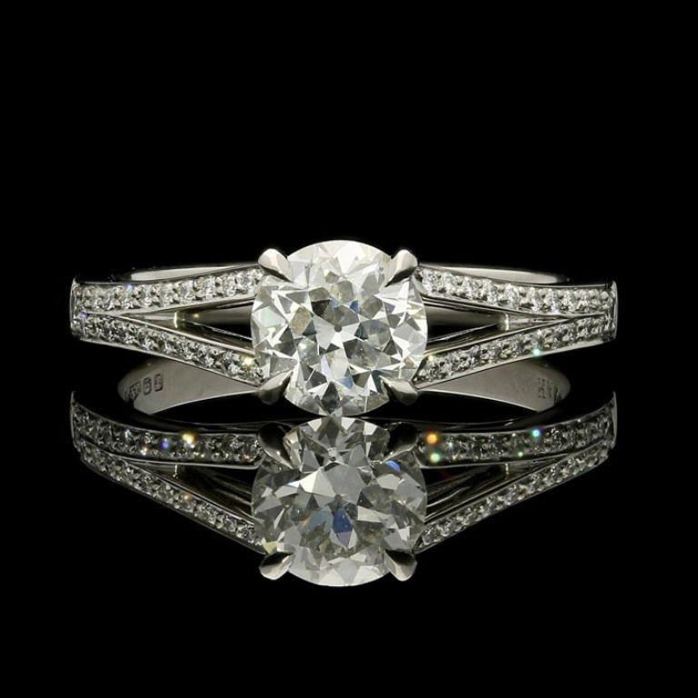 An elegant old cut diamond and platinum ring by Hancocks, centred with a beautiful old European brilliant cut diamond weighing 0.91cts and of G colour and VS2 clarity, claw set between split tapering shoulders set with round brilliant cut diamonds,