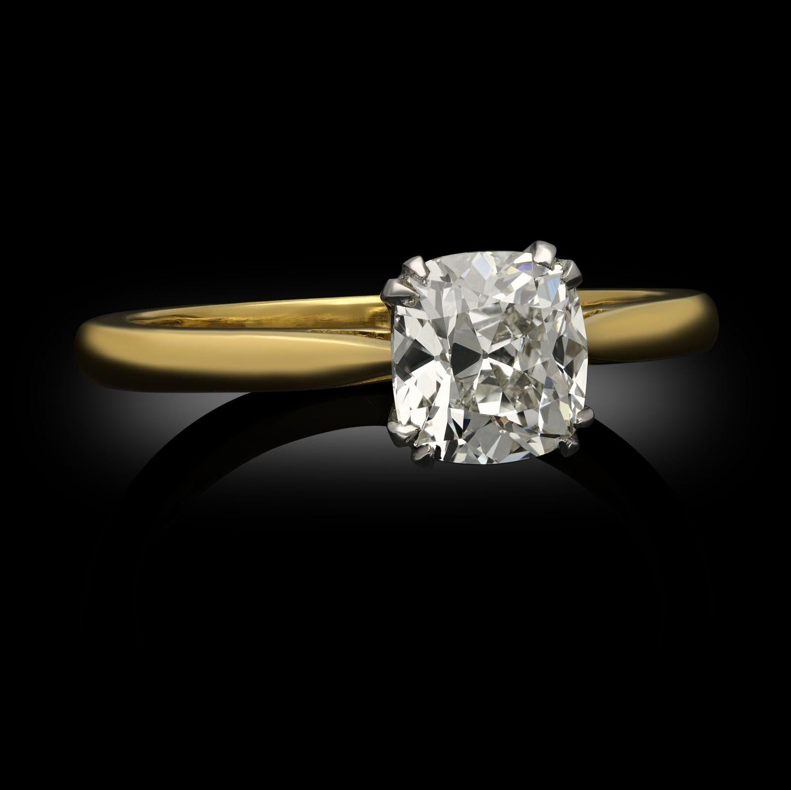 An old cut diamond and yellow gold solitaire ring by Hancocks. The ring is set with an old mine cushion cut diamond weighing 1.12ct, set with double claws in a scalloped platinum mount to a handcrafted 18ct yellow gold band with tapering shoulders