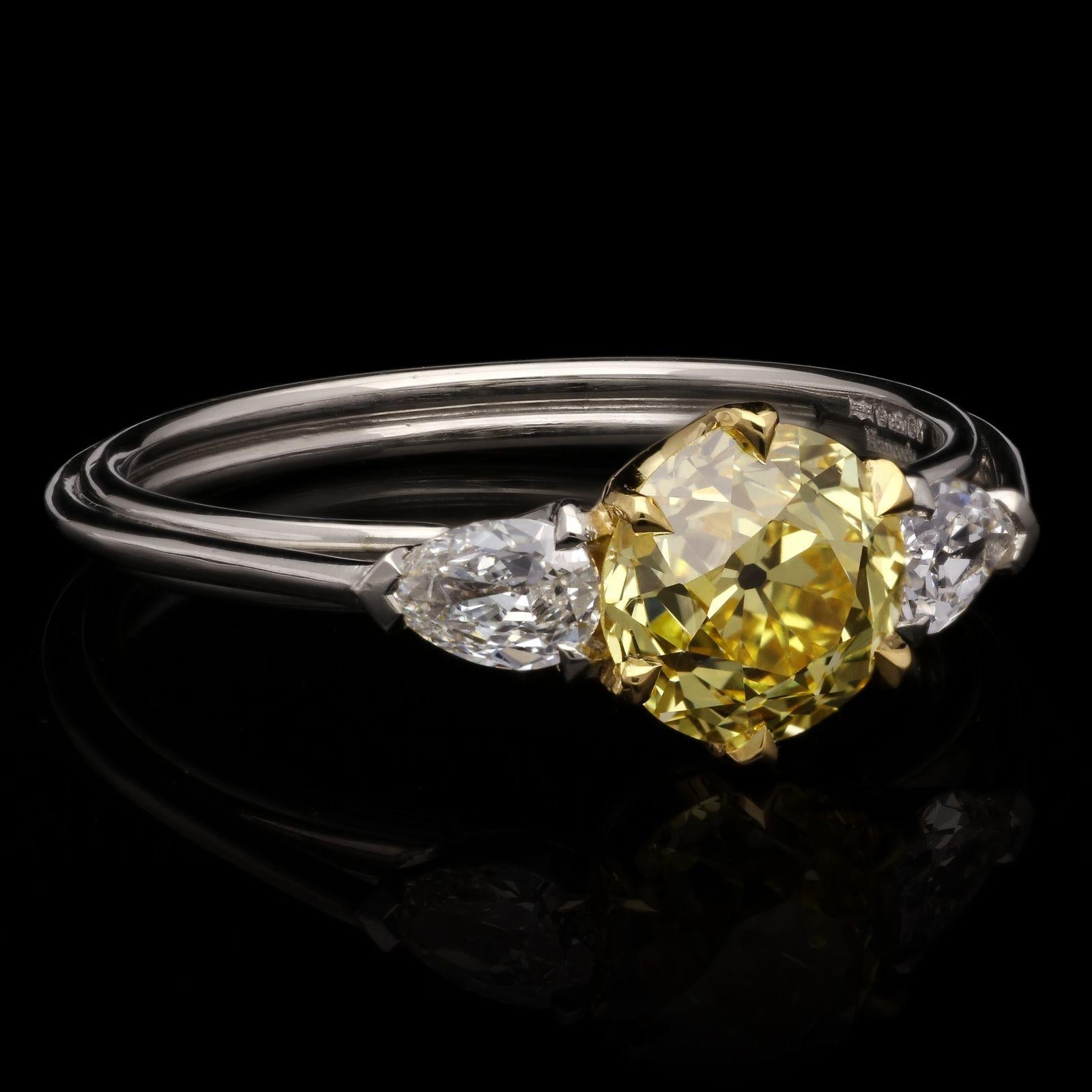 A beautiful old cut fancy diamond and white diamond ring by Hancocks, centred with a wonderful old European brilliant cut diamond weighing 1.27cts and of Fancy Intense Yellow colour and VVS2 clarity, claw set in 18ct yellow gold with open scooped