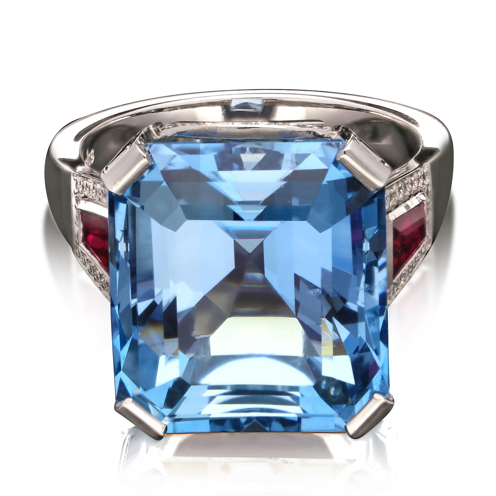 An aquamarine cocktail ring by Hancocks, centred with a beautiful emerald-cut aquamarine weighing 14.17cts corner-claw set in platinum, the scooped gallery embellished with round brilliant diamonds and each shoulder set with a tapered baguette ruby