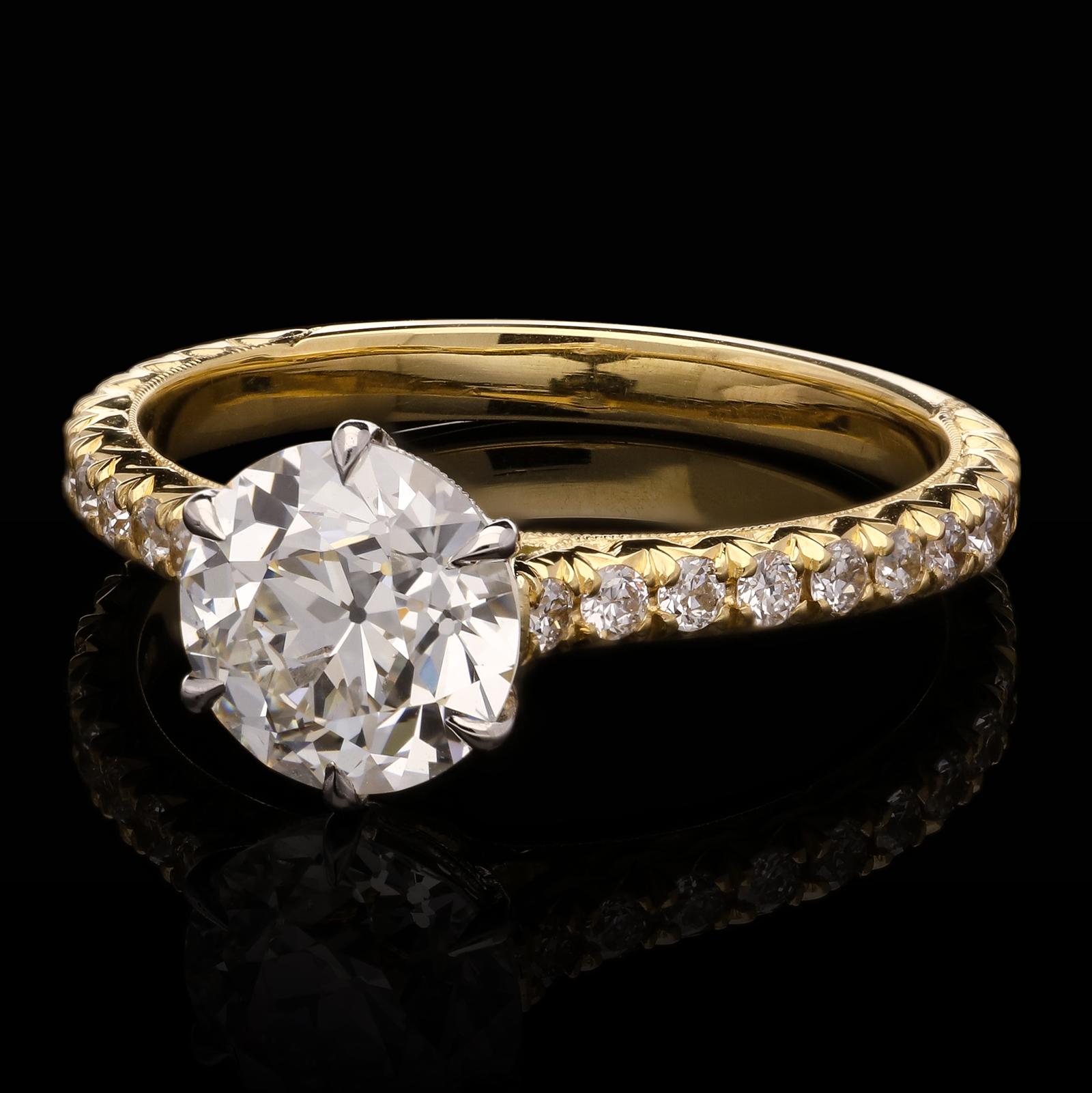 A classic old-cut diamond solitaire ring by Hancocks, centred with an old European brilliant cut diamond weighing 1.43cts and of I colour and VS2 clarity claw set in platinum with a hand engraved gallery, to an 18ct yellow gold mount, the shoulders