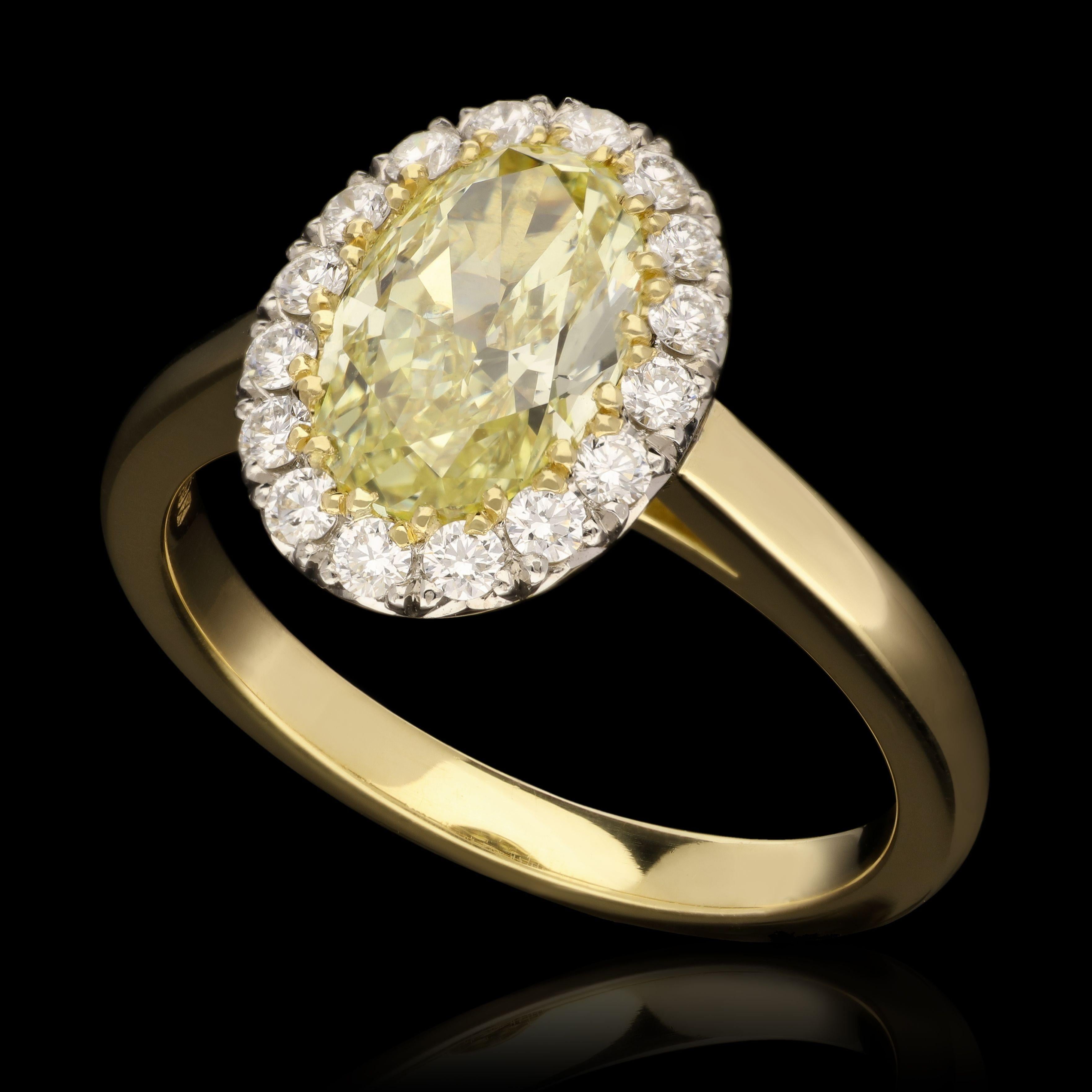 A classic oval yellow diamond cluster ring by Hancocks, centred with a beautiful bright and lively oval brilliant cut diamond weighing 1.54cts and of Fancy Yellow colour and SI1 clarity claw set within a halo surround of round brilliant cut