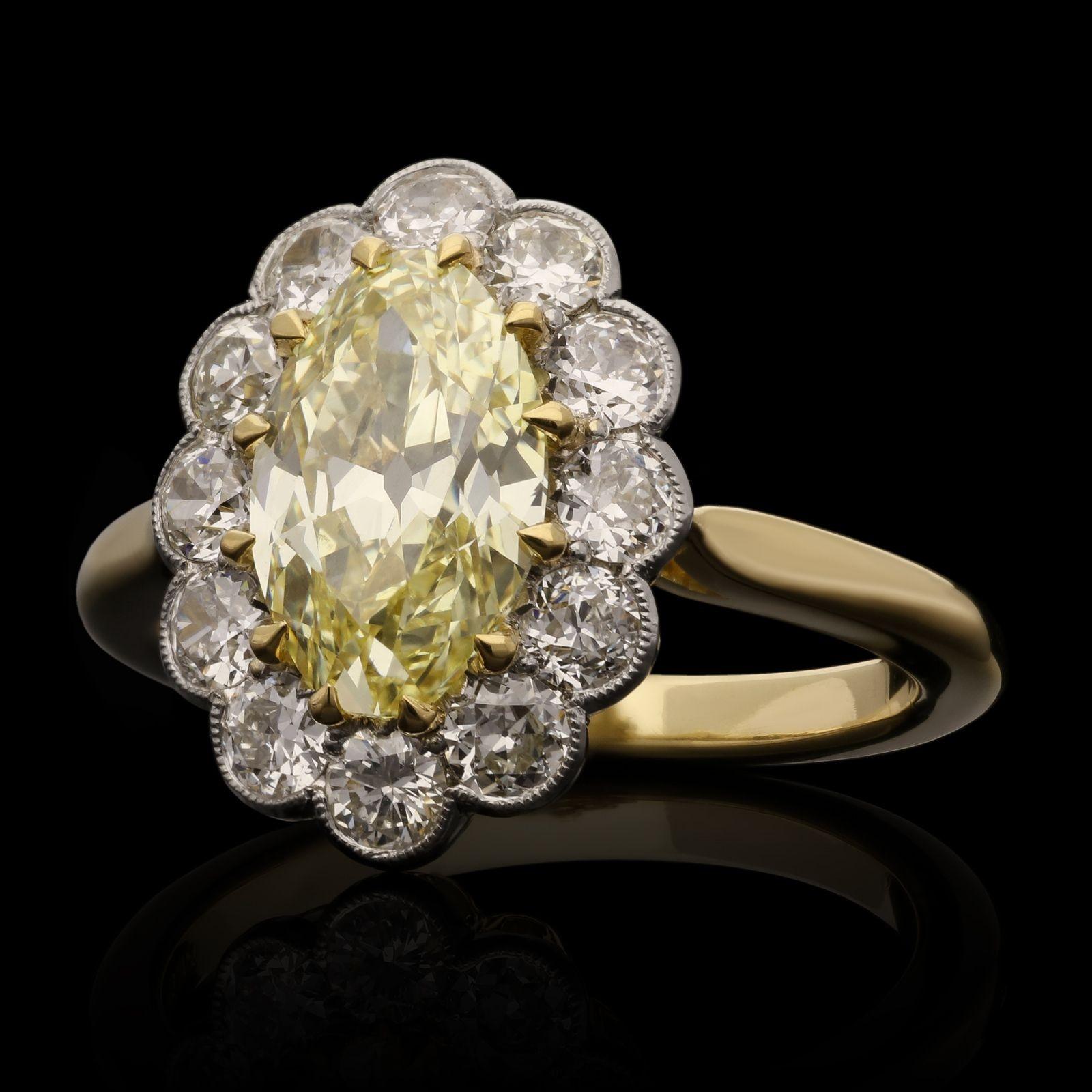 A classic oval yellow diamond cluster ring by Hancocks, centred with a beautiful bright and lively moval shape diamond weighing 1.83cts and of Fancy Yellow colour and VS1 clarity claw set in yellow gold within a halo surround of old European