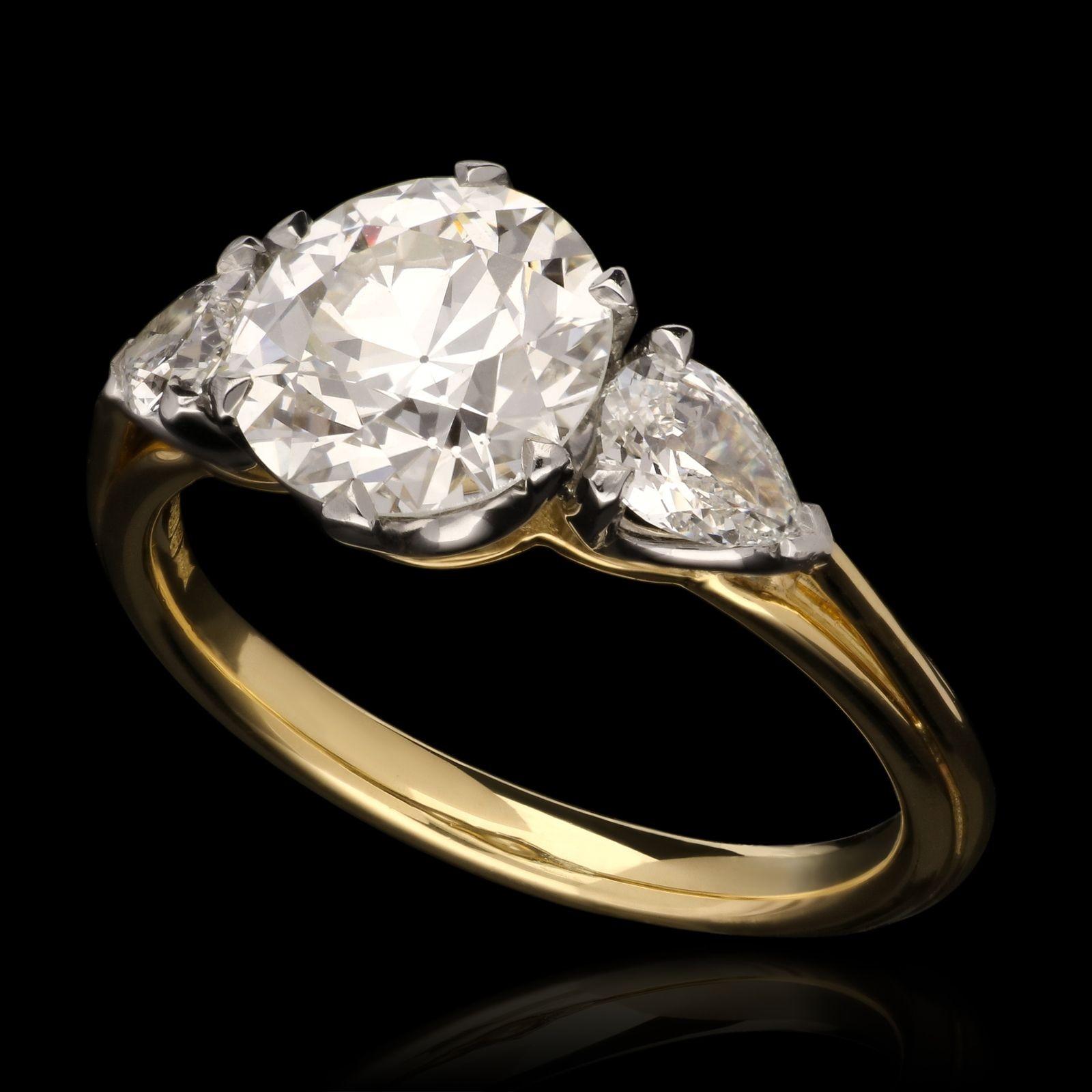 A beautiful old European brilliant cut diamond weighing 1.92cts claw set in 18ct yellow gold and platinum with open scooped gallery between shoulders set with old cut pear shaped diamonds in platinum claw settings, all to a finely hand crafted gold