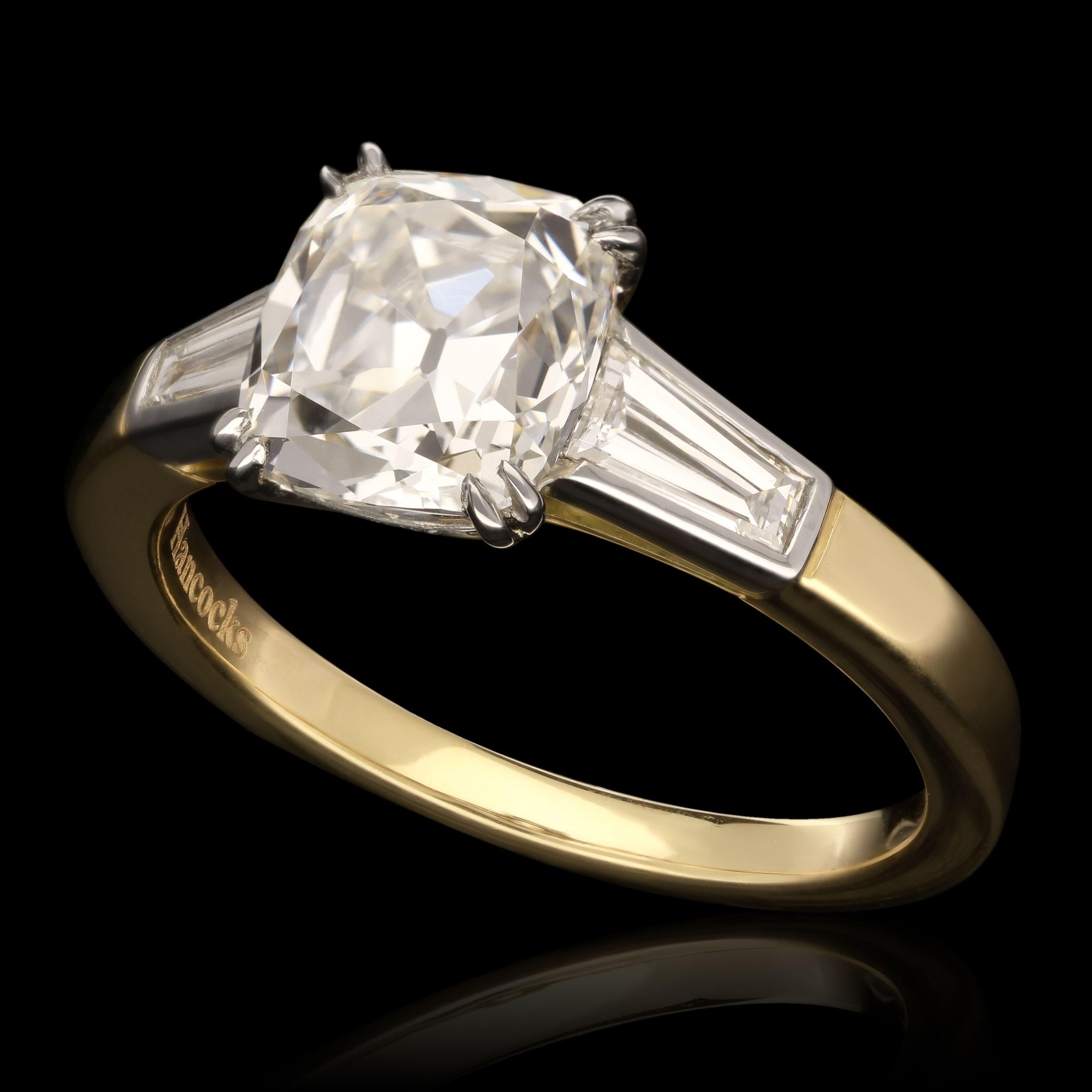 A beautiful old cut diamond ring by Hancocks, centred with a bright and lively cushion shaped old mine brilliant cut diamond weighing 2.01ct and of G colour and SI1 clarity claw set in platinum to a diamond-set gallery between shoulders of bezel set
