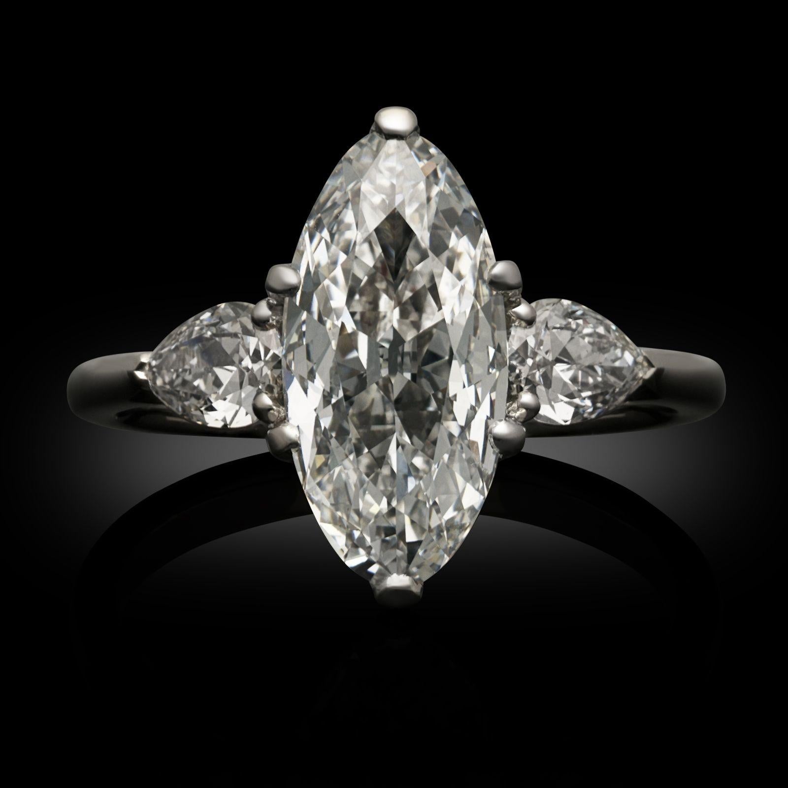 An old cut type IIA diamond and platinum ring by Hancocks. The ring is set with a 2.12ct D IF old cut moval diamond claw set in platinum to a scalloped gallery and set between pear shape diamond shoulders in claw settings, all to a handcrafted