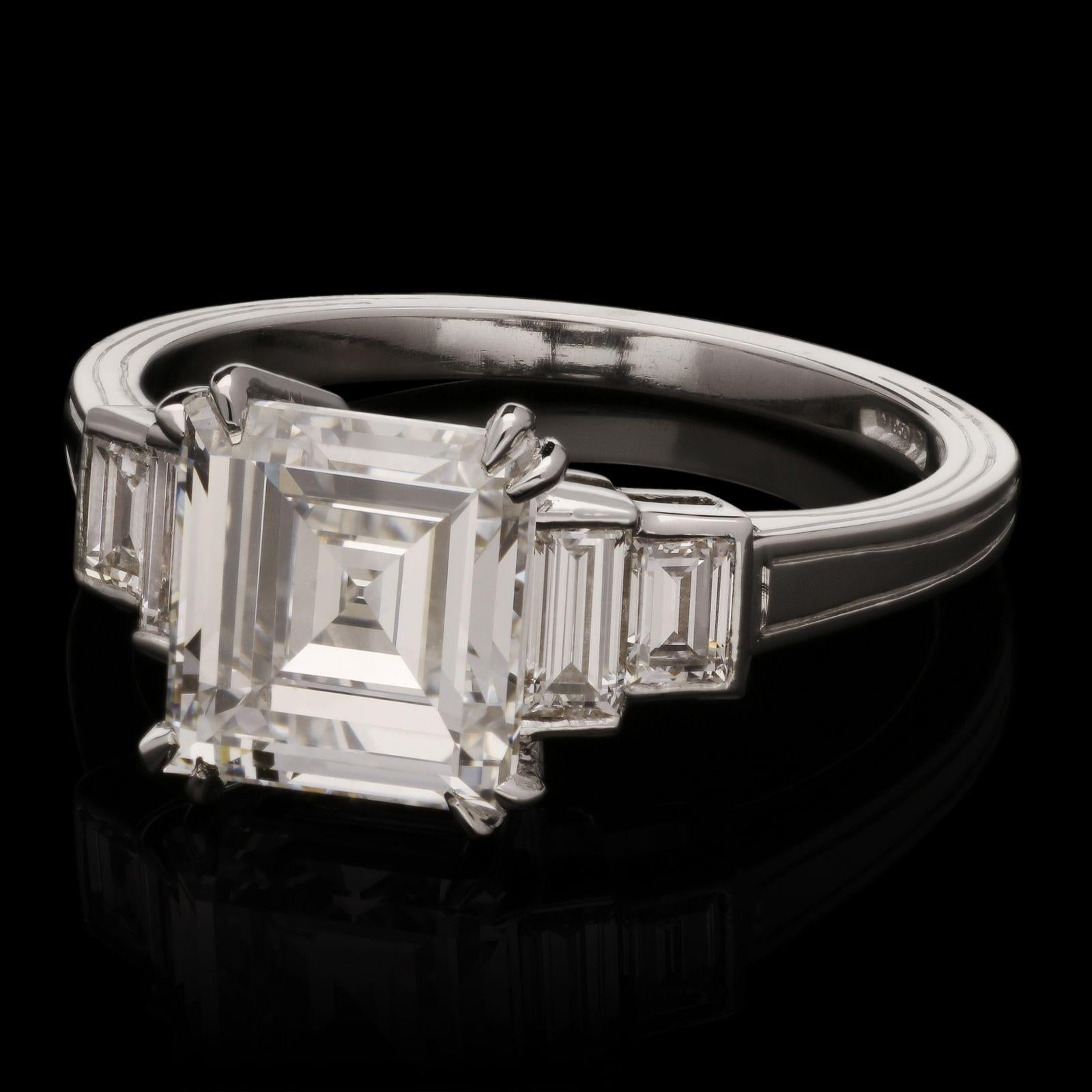 A beautiful Vintage carré-cut diamond weighing 2.28cts and of D colour and VS2 clarity, double corner-claw set between two baguette cut diamond shoulders either side, all in a finely crafted platinum mount with geometric engraved