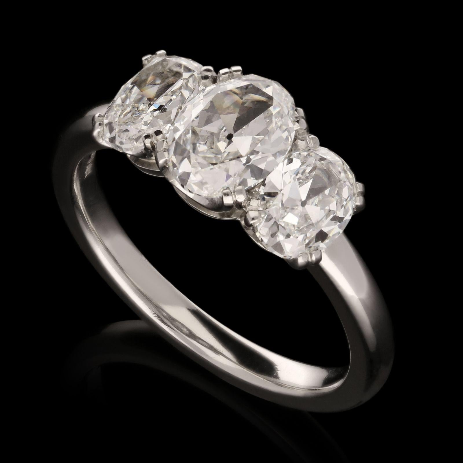 A classic diamond and platinum three stone ring by Hancocks, set to the centre with an oval brilliant cut diamond weighing 0.94cts and of F colour and VS2 clarity between two further oval brilliants of 0.54cts F colour and VS1 clarity and 0.52cts