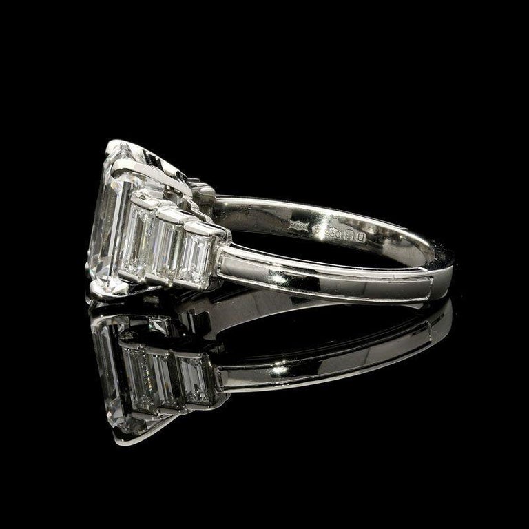 A stunning emerald-cut diamond ring by Hancocks, centred on a beautifully bright finest quality emerald-cut diamond weighing 3.19cts and of D colour and IF clarity corner claw set between shoulders of three stepped baguette-cut diamonds, all to a