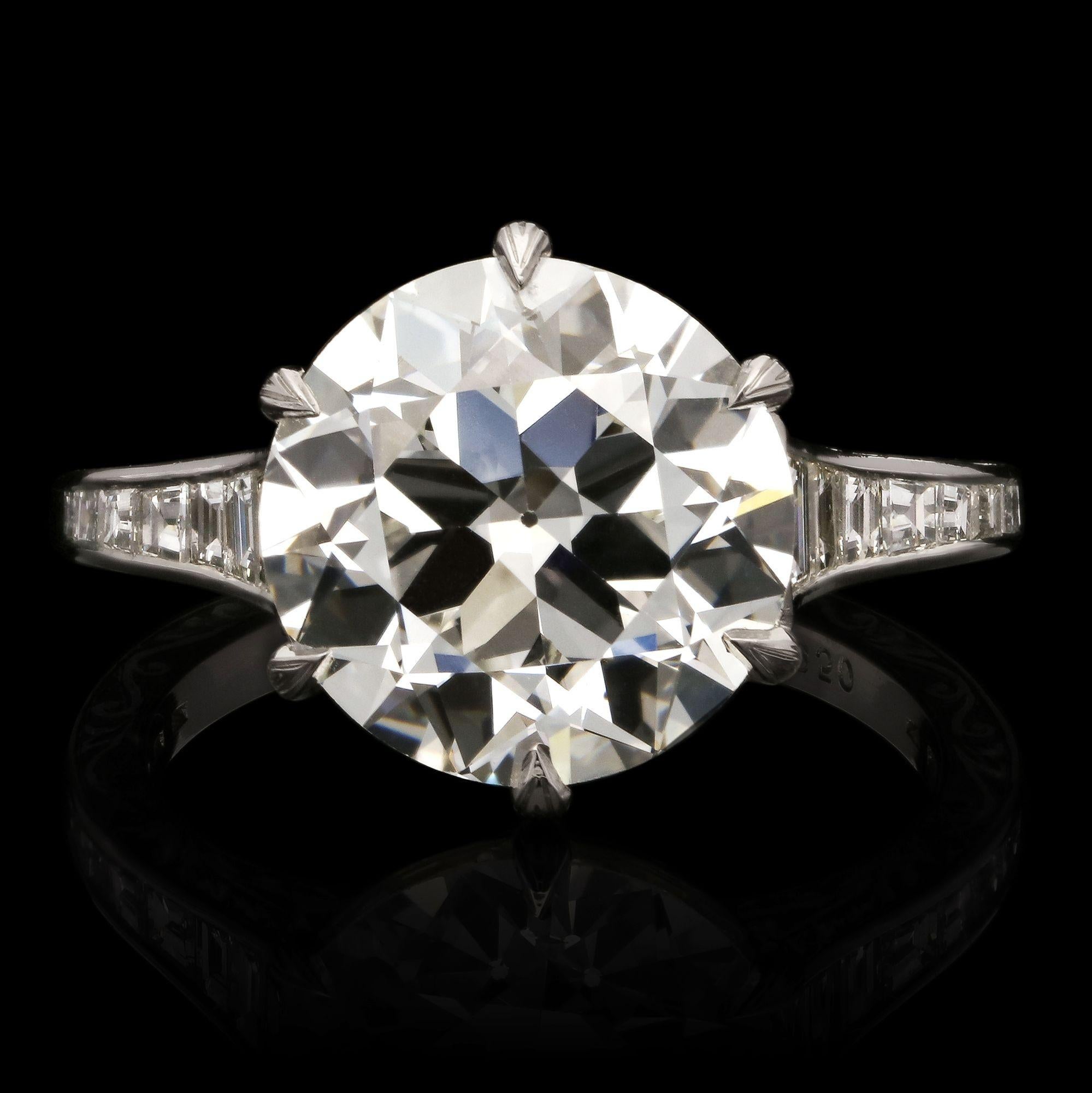 A beautiful old cut diamond ring by Hancocks set with a bright and lively old European brilliant cut diamond weighing 4.23cts and of G colour and VS2 clarity claw set in platinum between elegantly tapering shoulders channel set with calibre cut