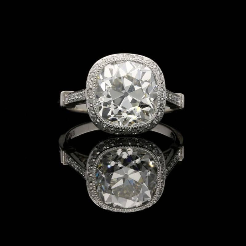A stunning cushion shaped diamond and platinum ring by Hancocks, centred on a beautiful old mine brilliant cut diamond weighing 4.51 Carats and of J colour and VS1 clarity set within a rubover millegrain surround to a finely crafted handmade