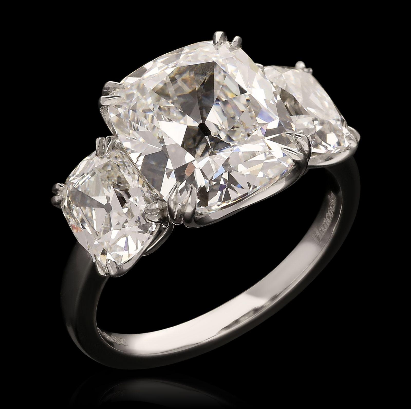 A stunning old-cut diamond and platinum three stone ring by Hancocks, set to the centre with an old mine brilliant cut diamond weighing 5.02cts and of G colour and VVS2 clarity between two further old mine brilliants of 1.03cts F colour and VS2