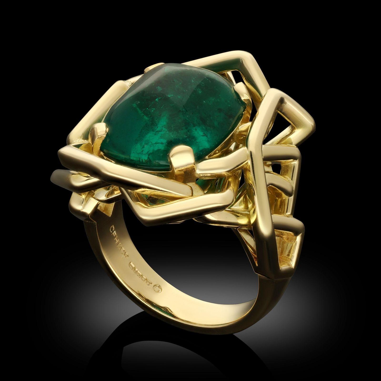A sugarloaf emerald and 18ct yellow gold ring by Hancocks. The ring has a central 8.59ct sugarloaf Colombian emerald set within a handcrafted asymmetric framework of 18ct yellow gold, tapering at the reverse to a smooth polished