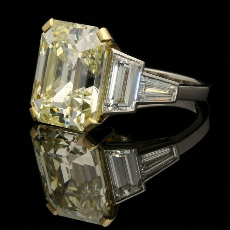 A magnificent emerald-cut diamond ring by Hancocks, the ring centred on a beautiful vintage-cut diamond weighing 8.73cts and of warm yellow tint with VS2 clarity, corner claw set between trapezoid and tapered baguette white diamond shoulders