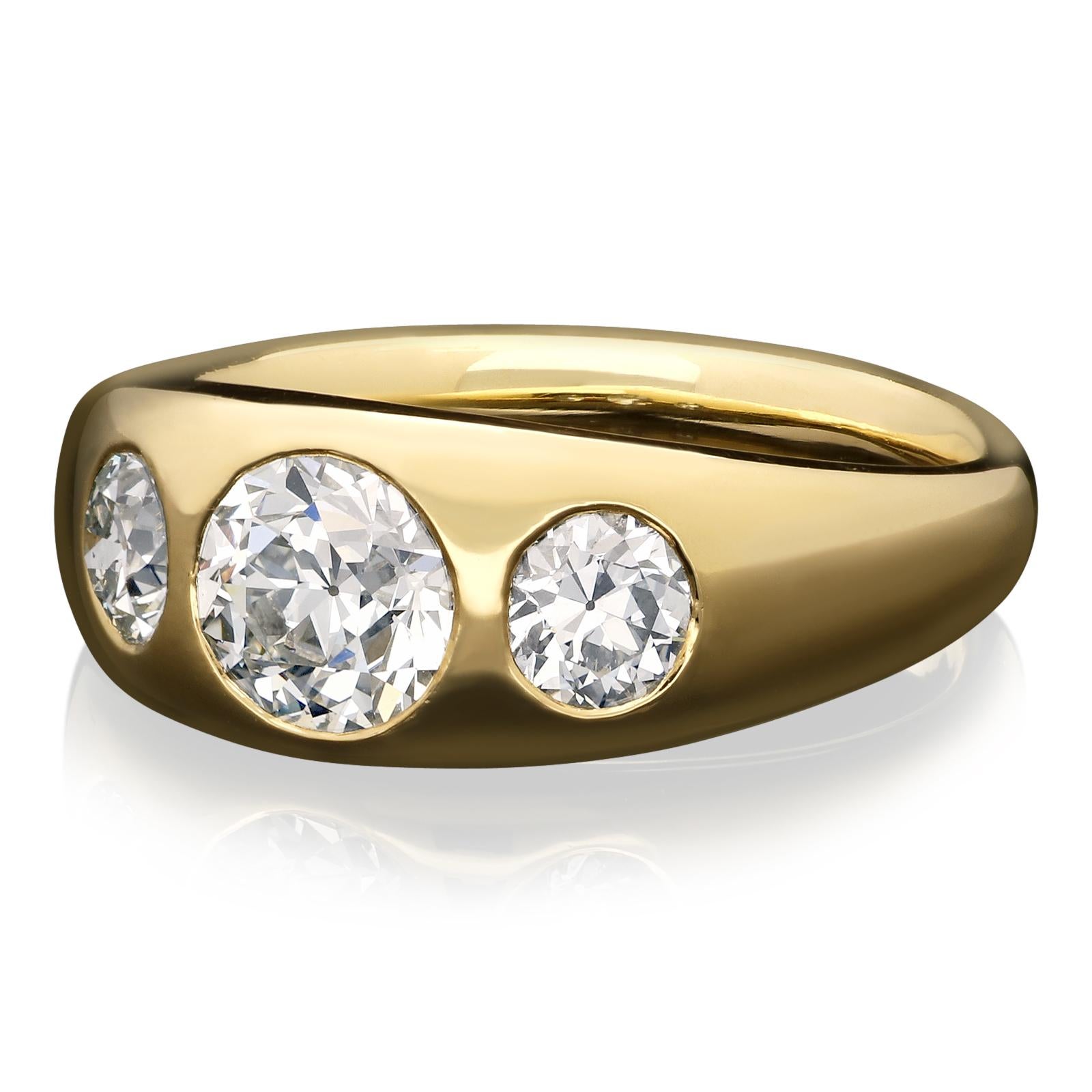 A beautiful 18ct gold and diamond gypsy-set three stone ring by Hancocks, set flush to the centre with an old European brilliant cut diamond weighing 1.08ct and of J colour and VS1 clarity between two smaller old European brilliant cut diamonds
