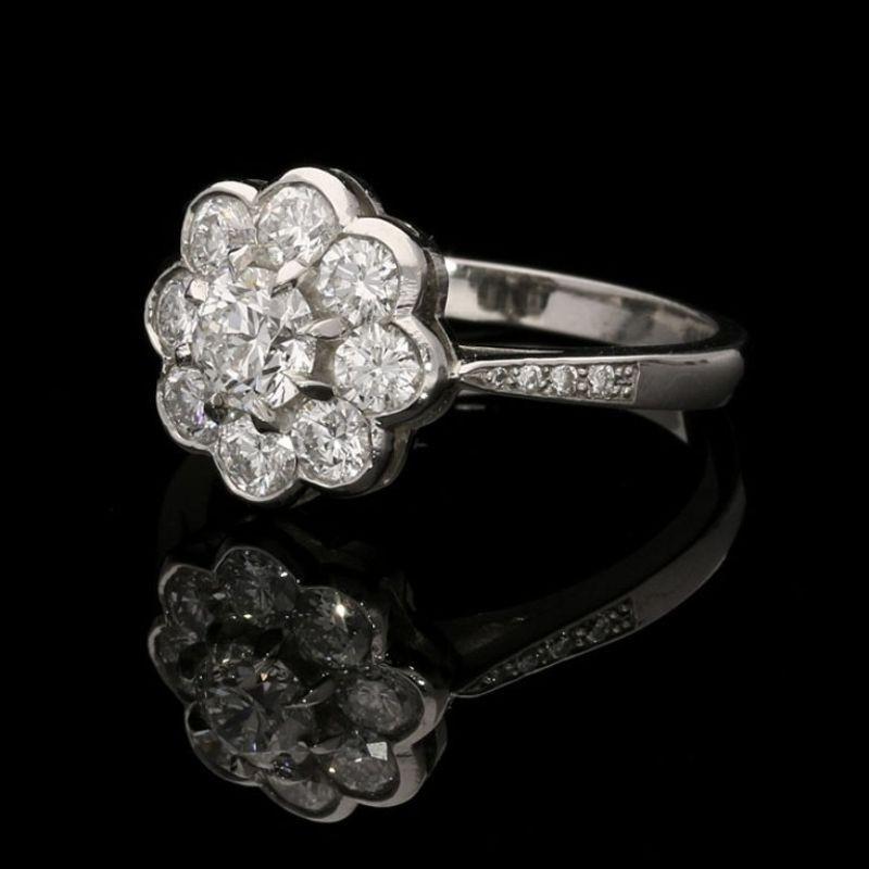 A pretty round brilliant cut diamond cluster ring by Hancocks centred on a 0.45ct round brilliant cut diamond of F colour and SI1 clarity surrounded by eight further round brilliant diamond petals all in a finely crafted platinum mount with tapering