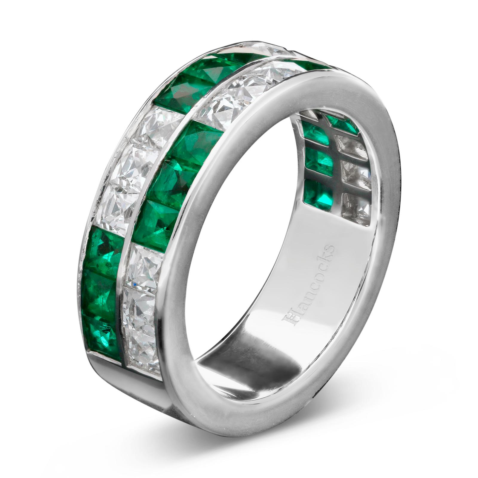 A striking and unusual double row eternity ring by Hancocks set to the front with two rows of alternating sections of three square French-cut emeralds and three square French-cut diamonds, all in a handmade platinum mount with straight band and hand