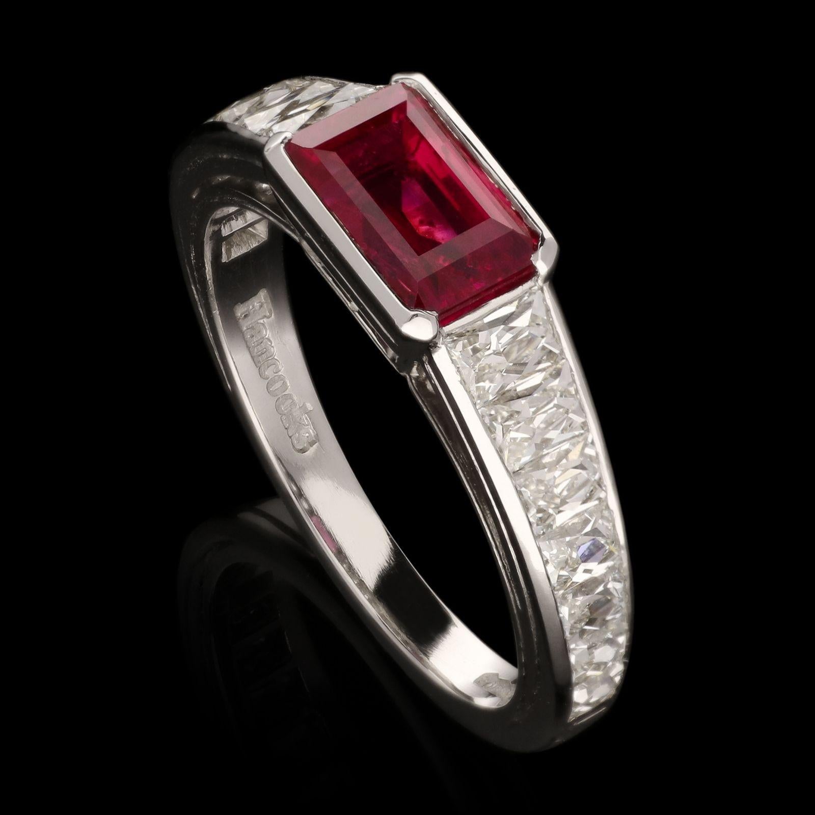An unusual ruby and diamond ring by Hancocks horizontally set with a rectangular step-cut unheated Burmese ruby weighing 1.75ct in a platinum rub-over setting between shoulders channel set with tapering French-cut diamonds to a tapering square