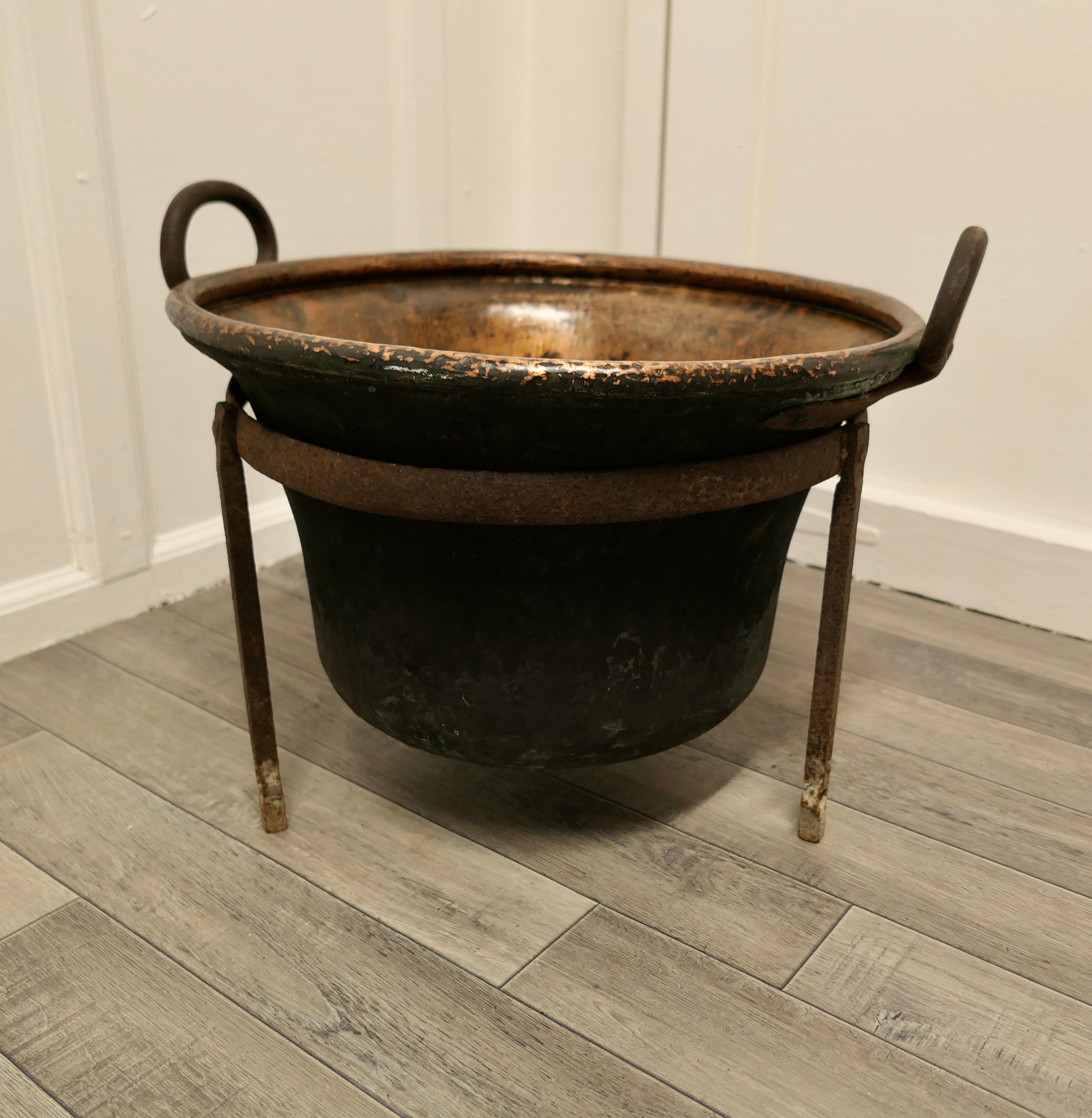 Hand beaten copper cooking cauldron on stand, log basket

This is a lovely early Cooking Pot, it is made in hand beaten copper, slightly flaring out at the top with a sturdy handle on each side
The pot has a rolled top edge, Iron handles and sits