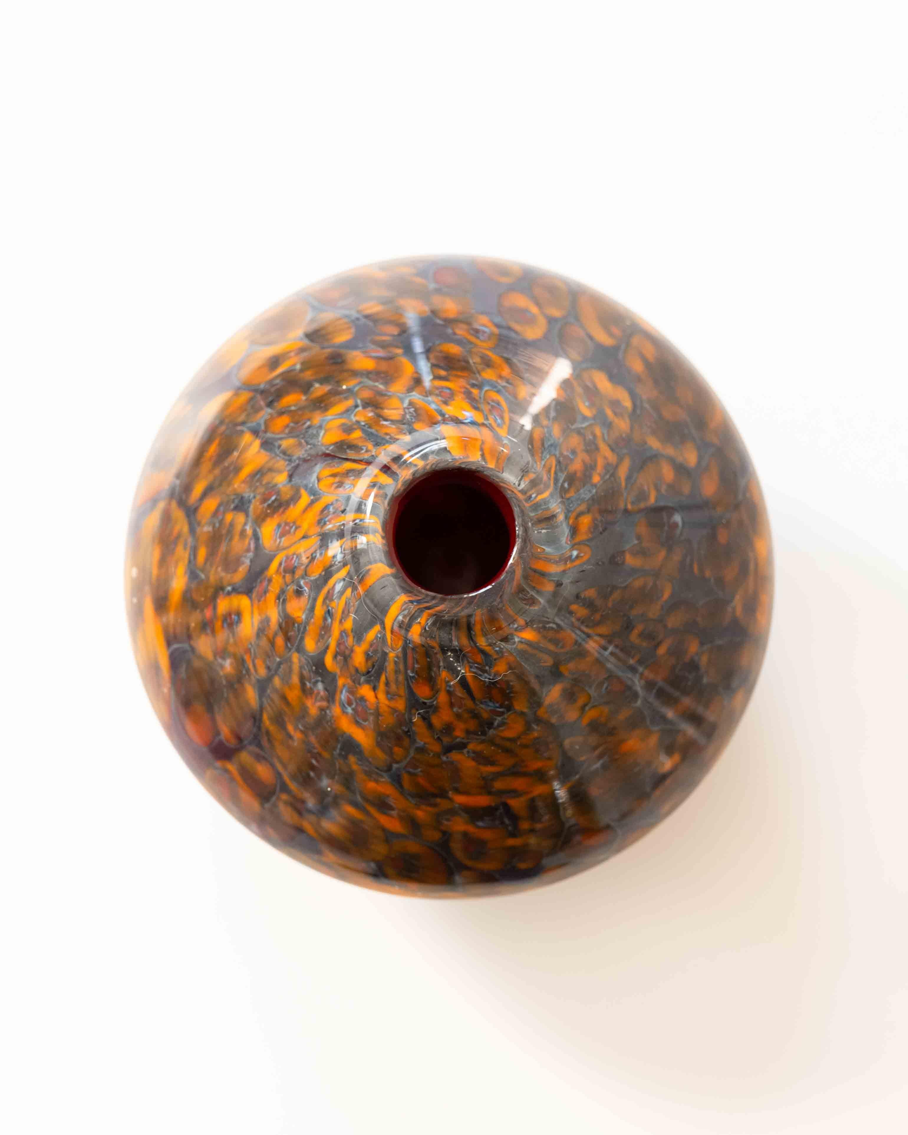 Le vase en verre écaille de tortue est une forme sculpturale en verre avec un motif riche et organique rappelant la terre fondue ou la carapace d'un animal. Soufflée à la main dans des tons ambrés et bruns profonds, sa silhouette basse et large