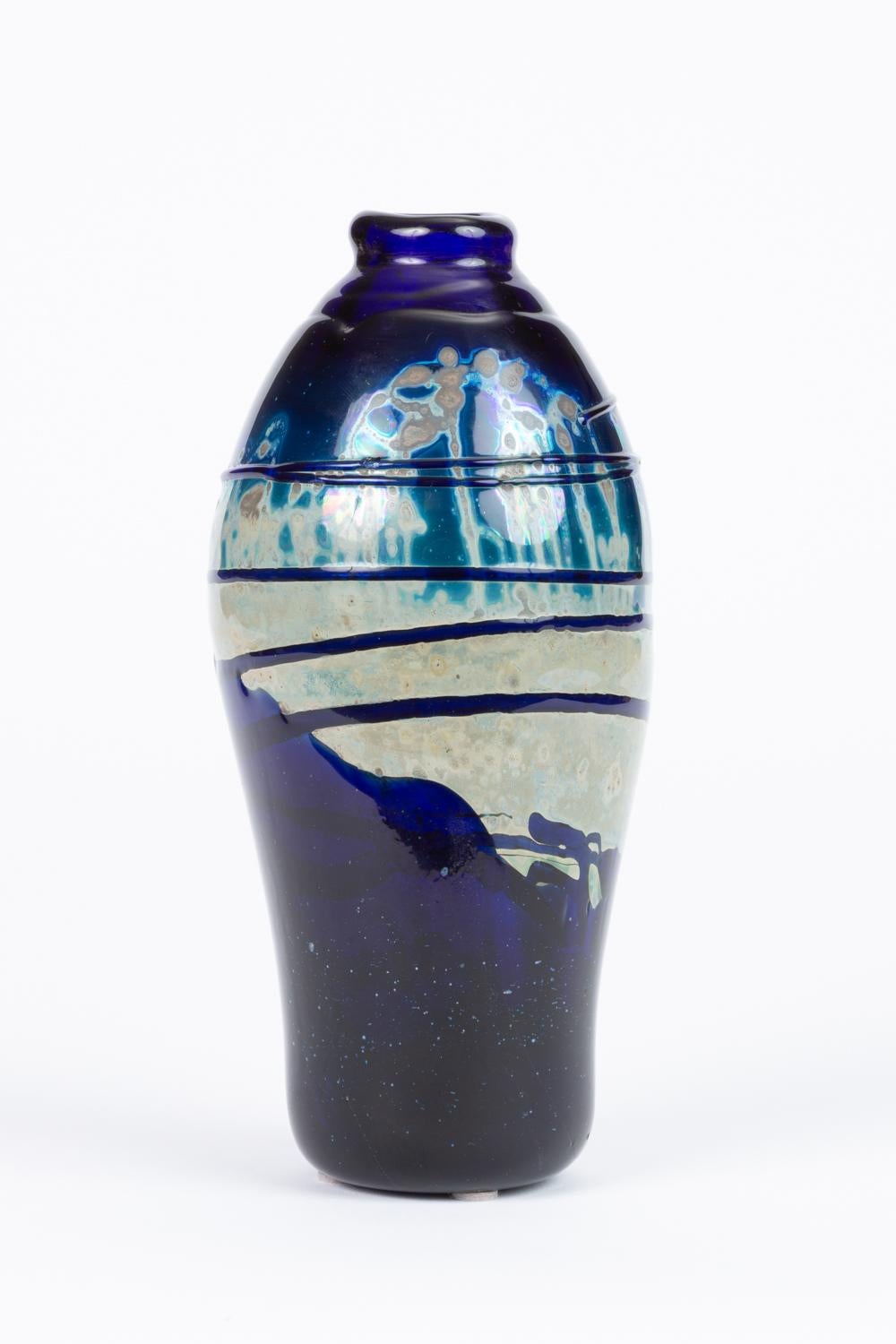 A striking hand blown vase in dark navy blue glass, with a striated drip finish in the center of the piece. Signed by the artist 