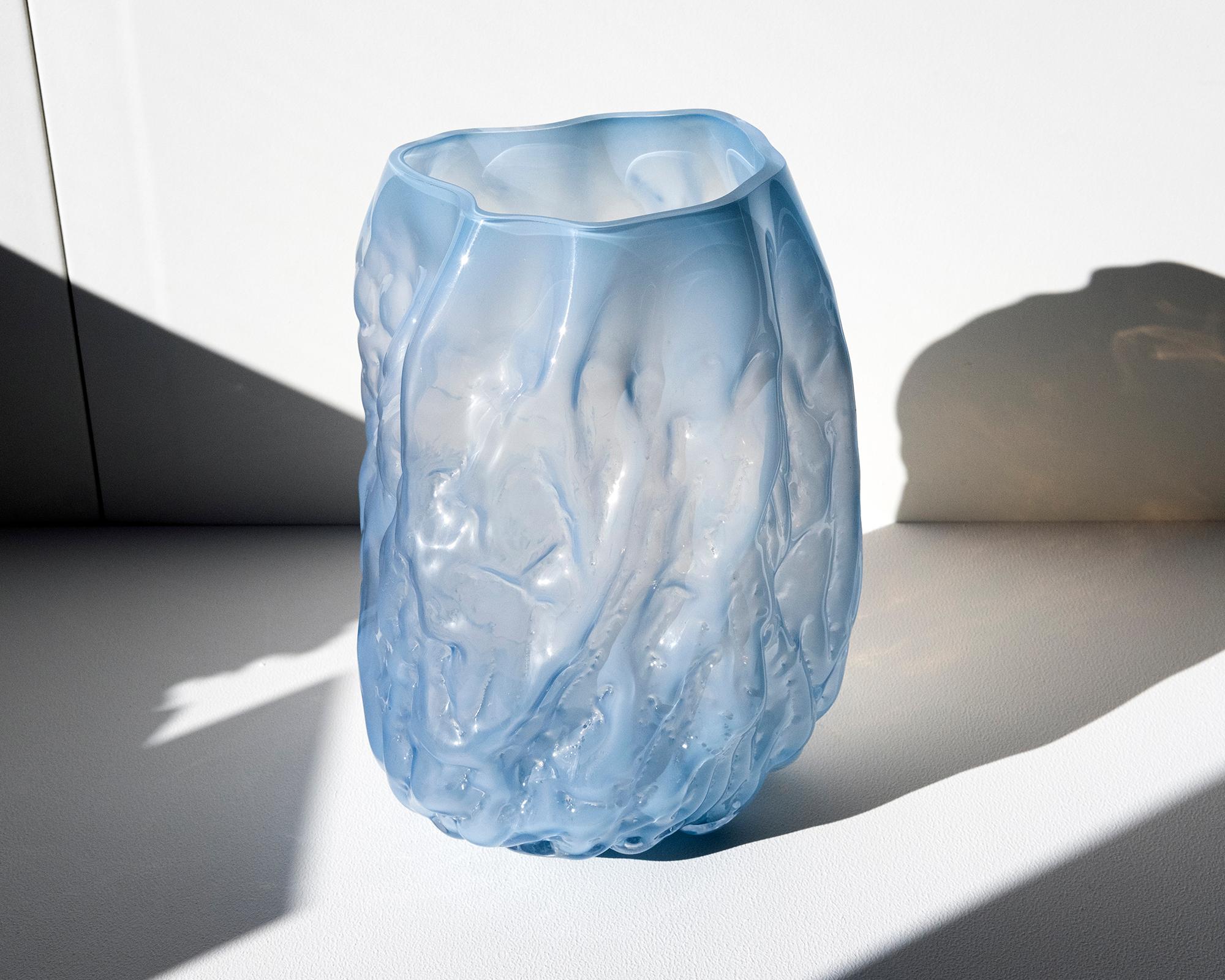 Unique Piece. Hand blown glass vase made in forms of soft clay that are shaped by hand just before blowing the glass into the form. The process makes all pieces unique and gives them a wrinkled surface. NOTE, small parts of clay from the production