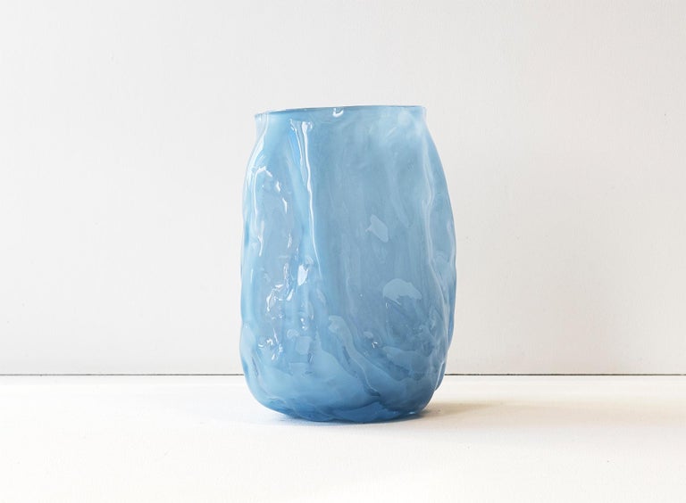 Unique Piece. Hand blown glass vase made in forms of soft clay that are shaped by hand just before blowing the glass into the form. The process makes all pieces unique and gives them a wrinkled surface. Note, small parts of clay from the production