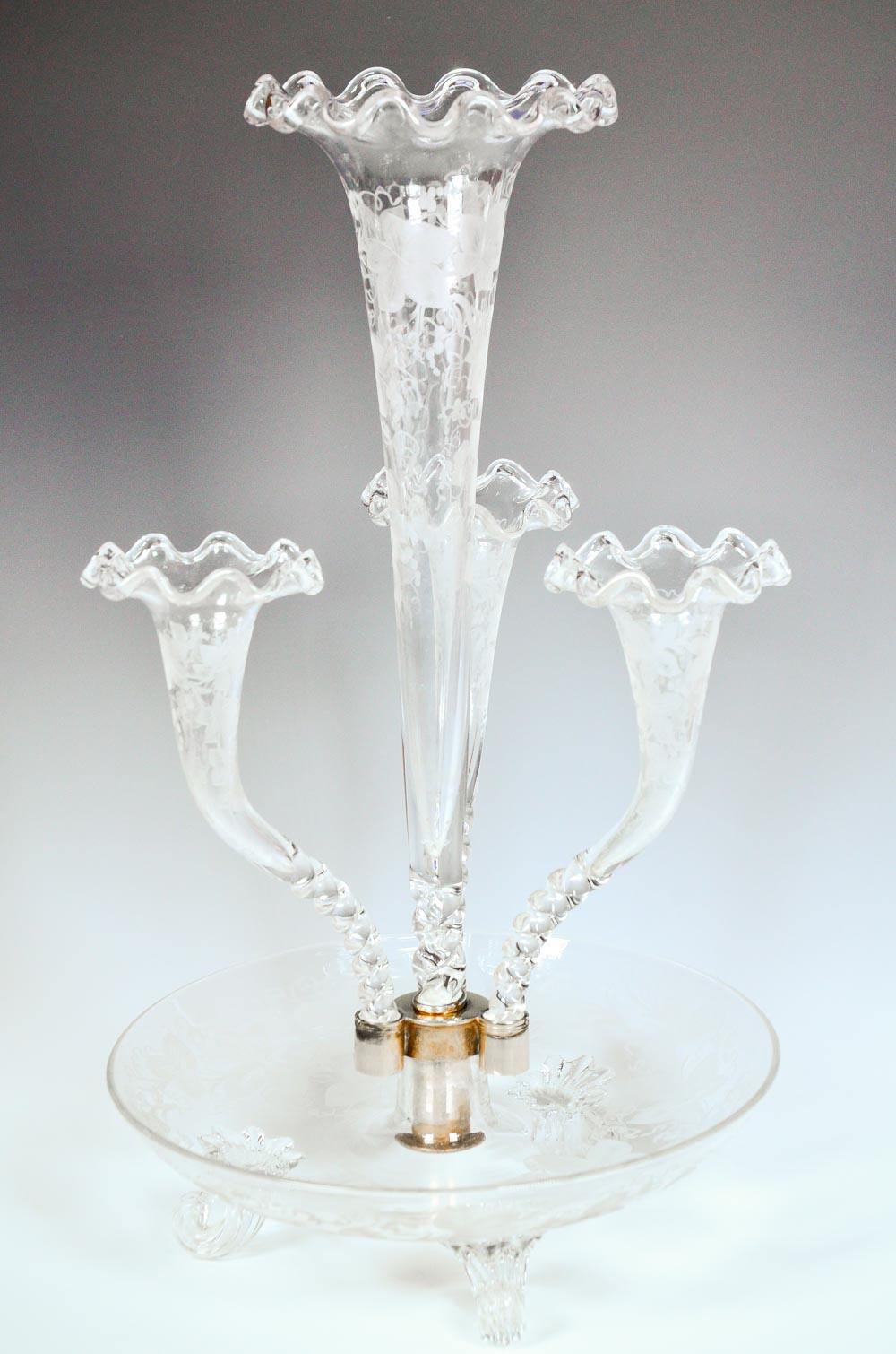 This is an exceptional example of an English epergne featuring a tall center vase surrounded by 3 curved trumpets. Each piece is hand blown and decorated with copper wheel engraved grapes and vines with foliage. The openings are embellished with