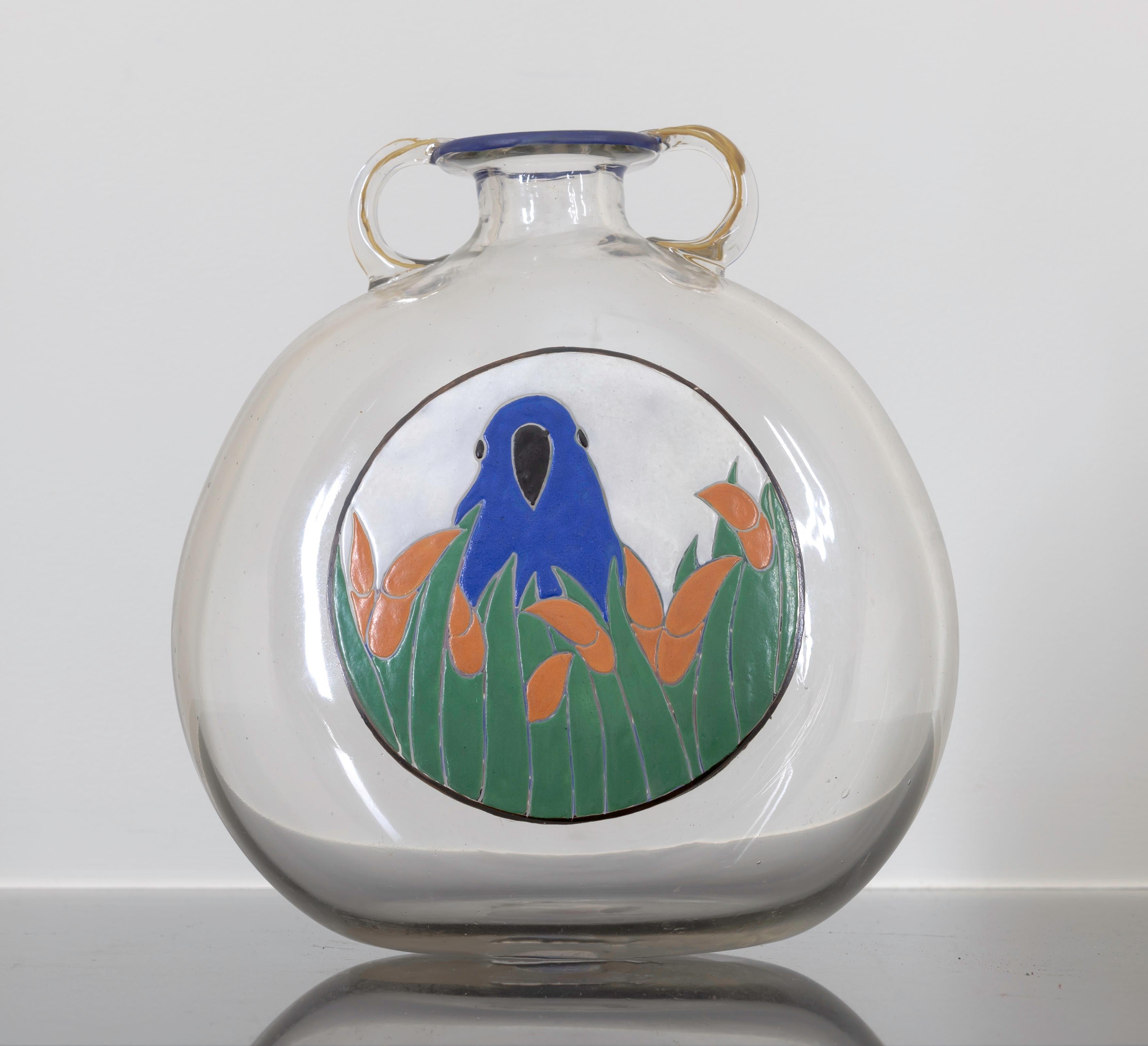 A clear hand blown vessel with an image of a bird on both sides. With mark of the artist under the base.