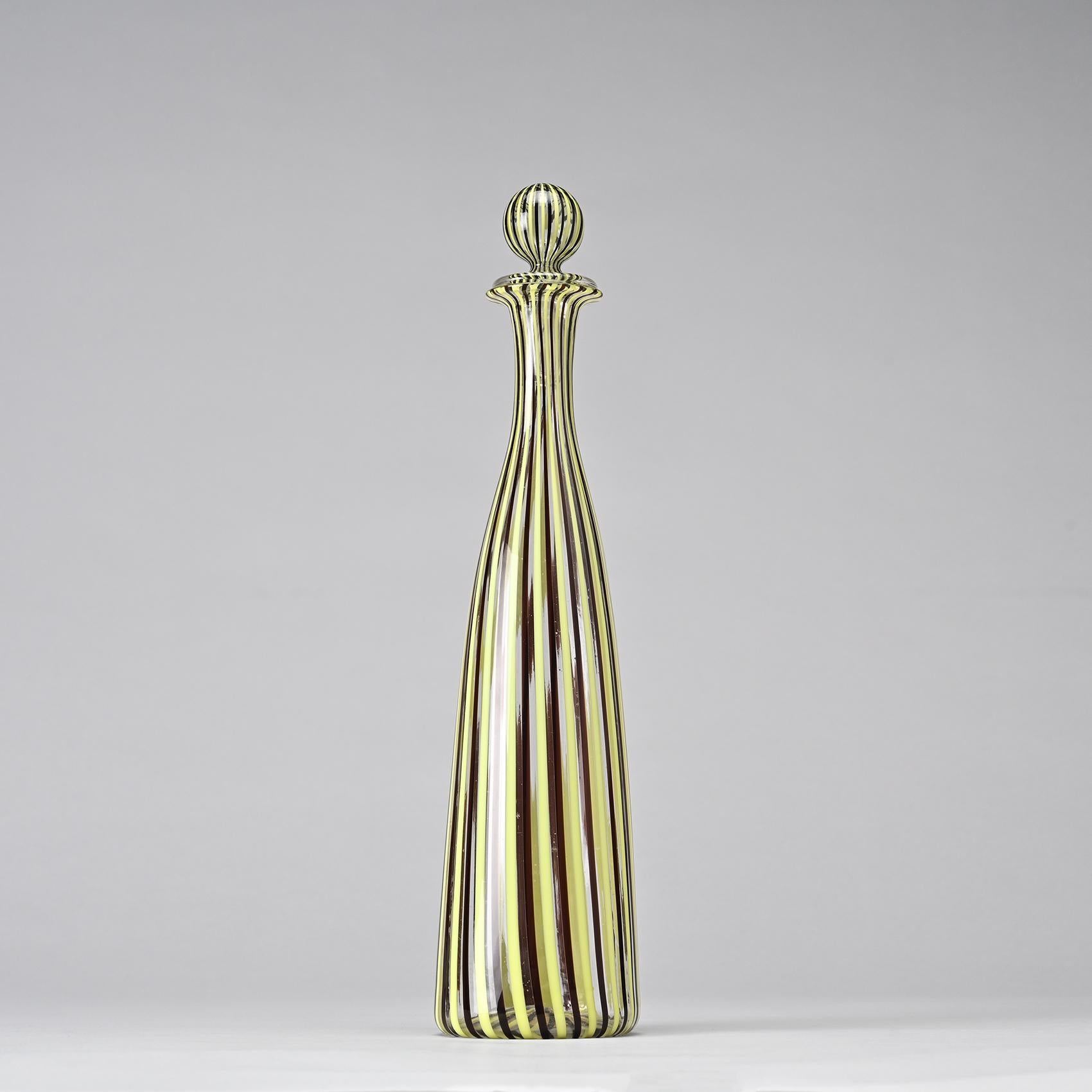 Clear blown glass bottle with yellow and black filigree decoration by Fulvio Bianconi, sealed with a spherical stopper.

Venini label on the back.

Manufactuer: Venini, circa 1950.

Bibliography: Similar model in Murano Milano Venezia glass, Die