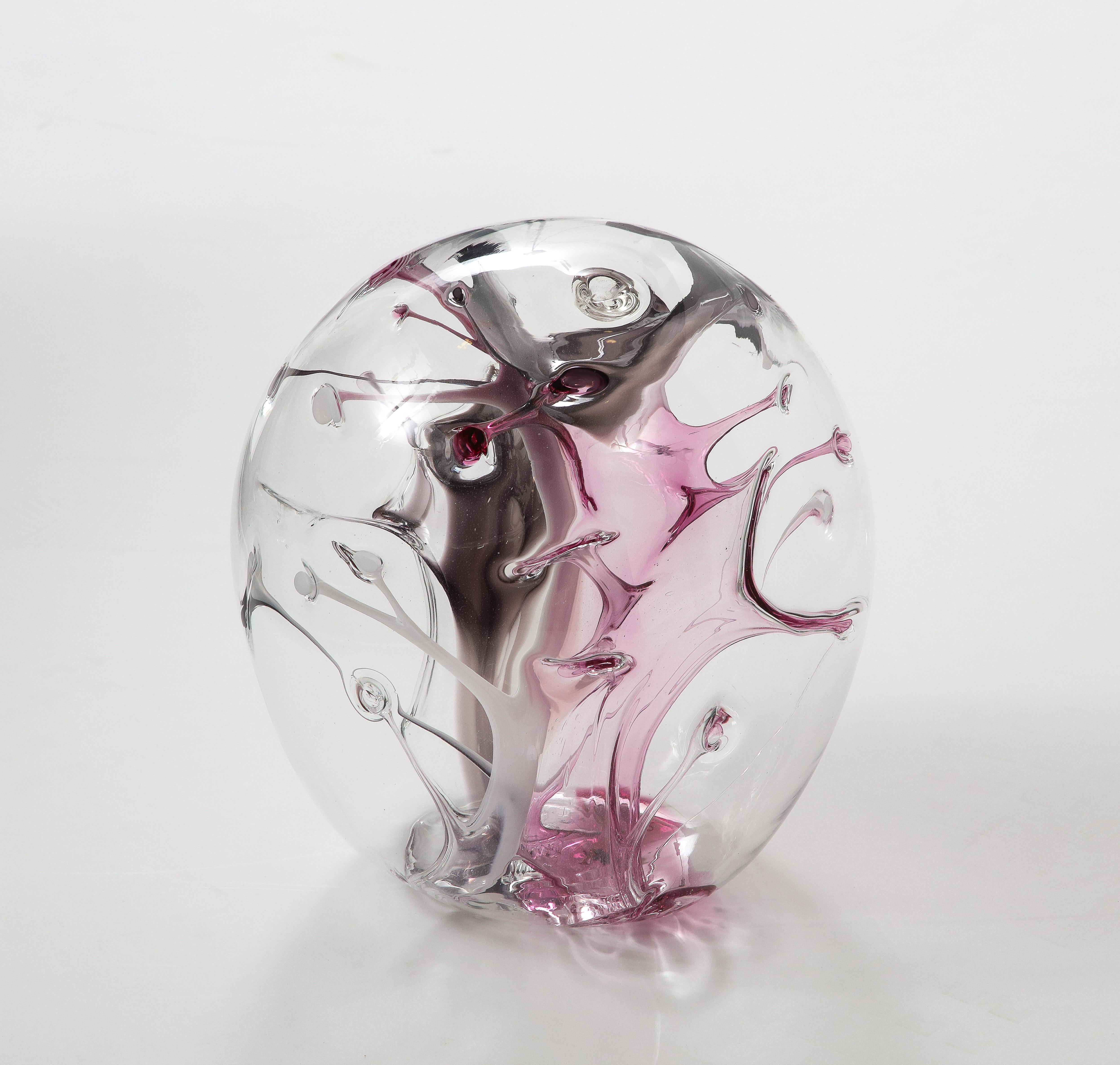 Hand blown glass orb sculpture by Peter Bramhall.
The glass orb has internal glass threads of  Clear, Magenta  and Black.
It is signed and dated on the bottom as shown in the last image.