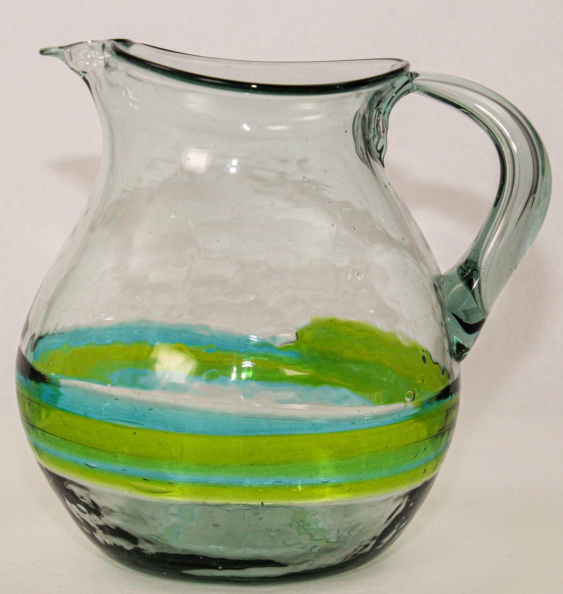 Hand blown Glass Pitcher With Green and Blue Swirl Design Mexico 1970s.
Handcrafted blown art glass Pitcher perfect for summertime iced tea or lemonade or your favorite cocktail.
The pitcher has an applied clear handle and is mouth blown with green
