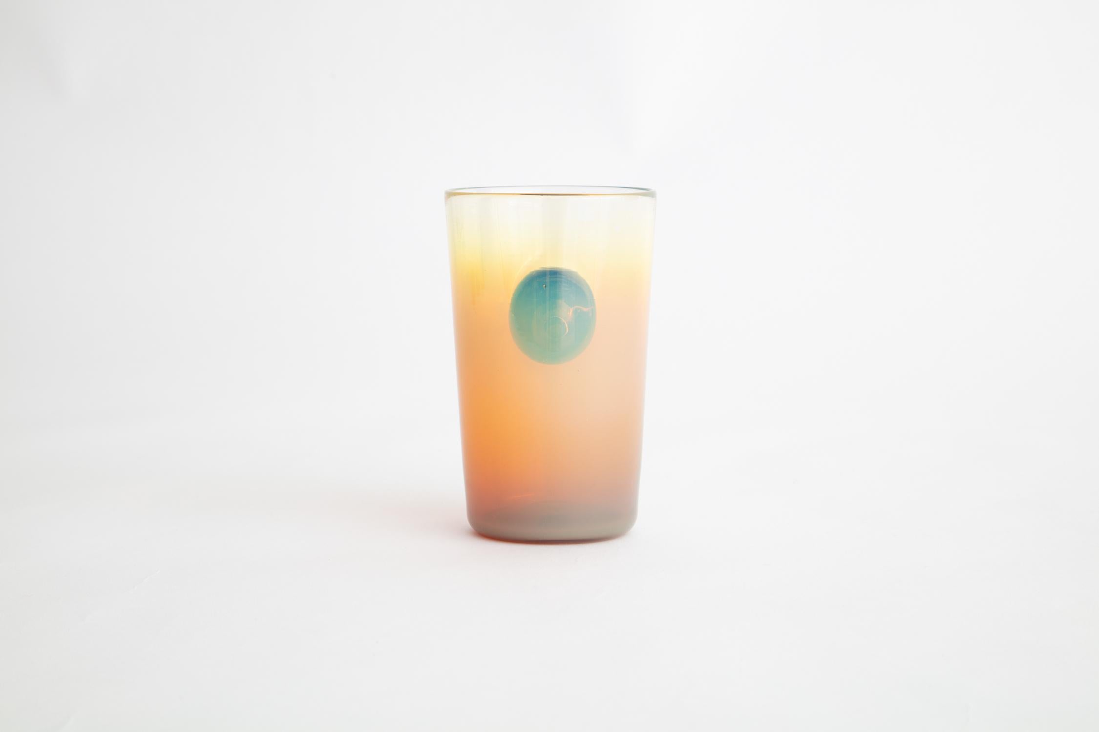 Surrealist-inspired sunrise sunset cups are hand blown in a kaleidoscope of ombre colors and adorned with contrasting orb handles to evoke a looking glass, a glimpse into a miniature universe.

Handmade by Jason Bauer and Romina Gonzales
Materials: