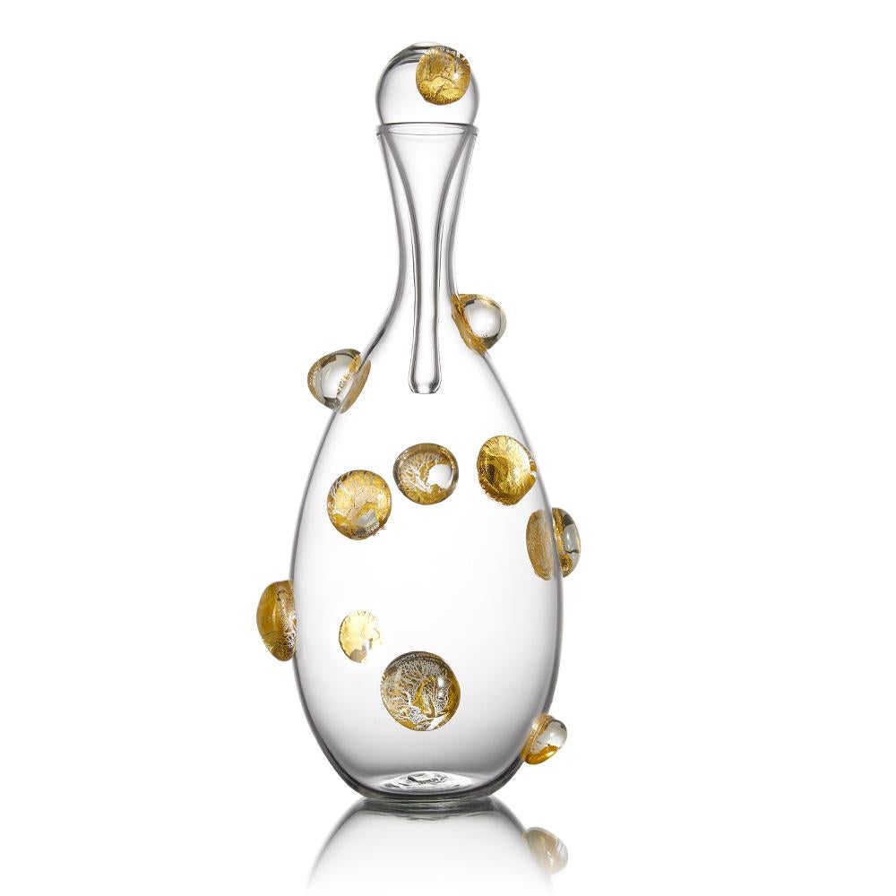 The Festa collection of hand blown glass decanters and barware features a celebratory, golden confetti pattern of optic glass dots. Encased gold leaf is magnified by the raised dot pattern, and decorates the surface of each carafe. A festive and