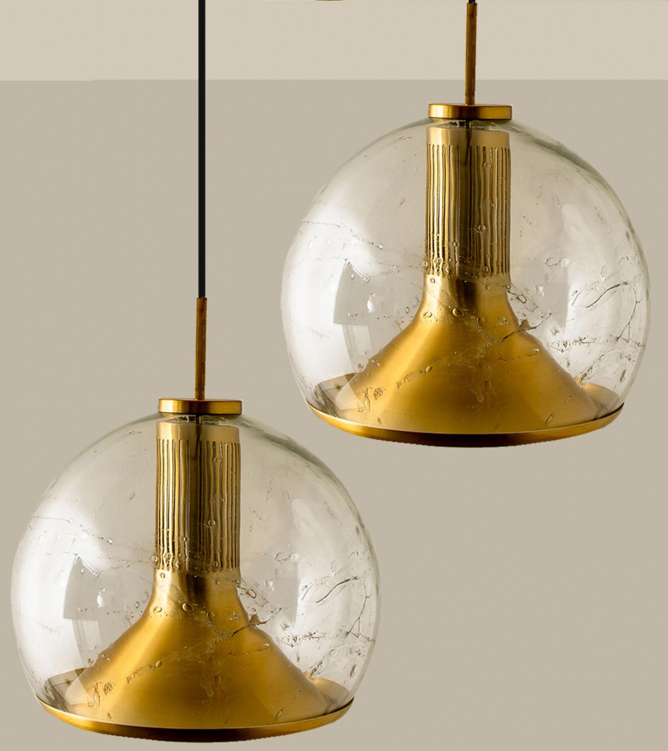 Several Large glass and brass ceiling lights from the 1970s of the factory Doria Leuchten, Germany, Europe. The lamp has a clear glass bulb with a brass fitting. A high quality piece. True craftsmanship of the 20th century.

The timeless elegance of