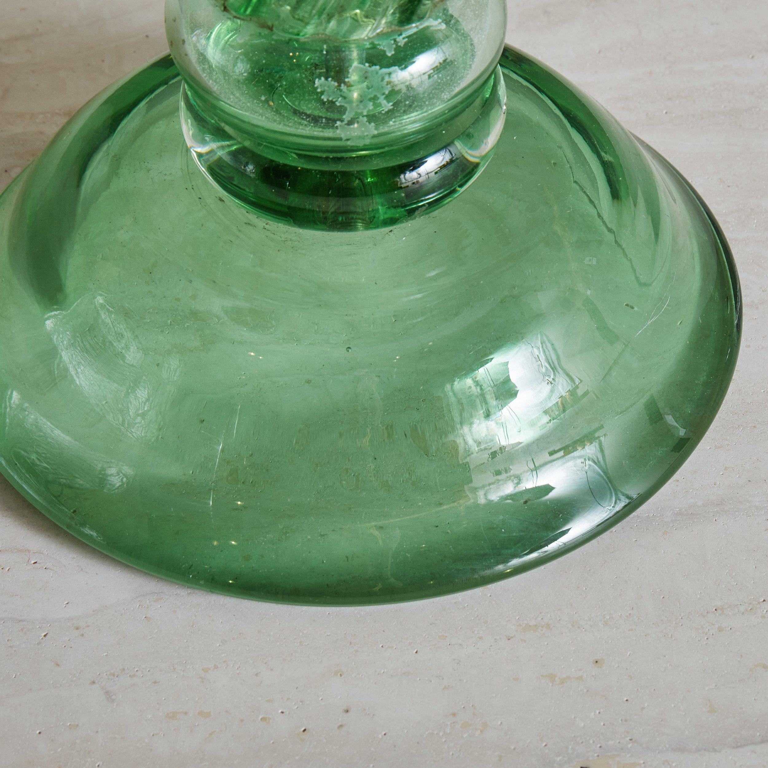 A 1940s Italian table lamp hand blown with Murano glass in a striking emerald green hue. This lamp has a swirled pedestal base and was newly rewired with brushed brass hardware. Lampshade is not included. Unmarked. Sourced in Italy, 1940s.
 

